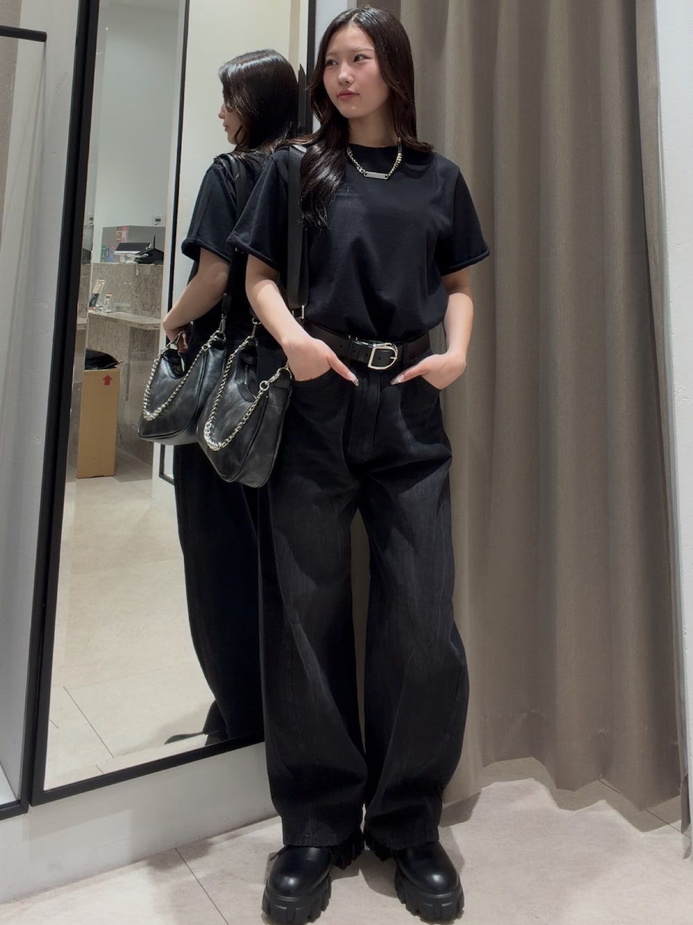 ブラック系のデニムパンツ、ブラック系のショルダーバッグ、ブラック系のTシャツ/カットソーを着用したレディースの夏コーディネートの2枚目の写真