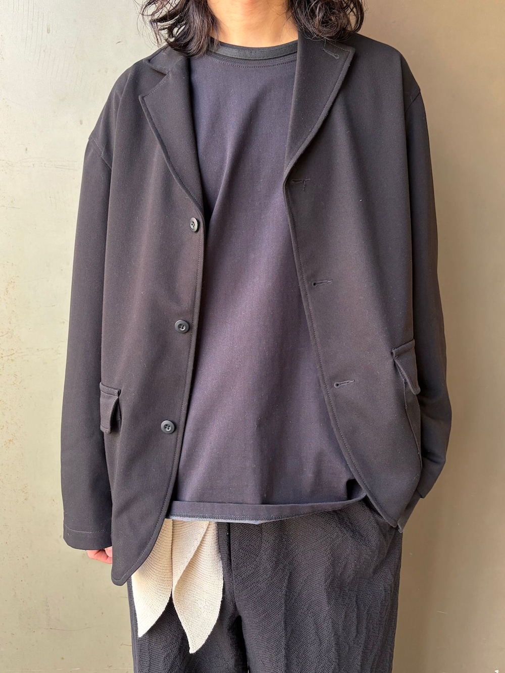 ブラック系のテーラードジャケット、ブラック系のスラックス、ブラック系のTシャツ/カットソーを着用したメンズの春コーディネートの5枚目の写真