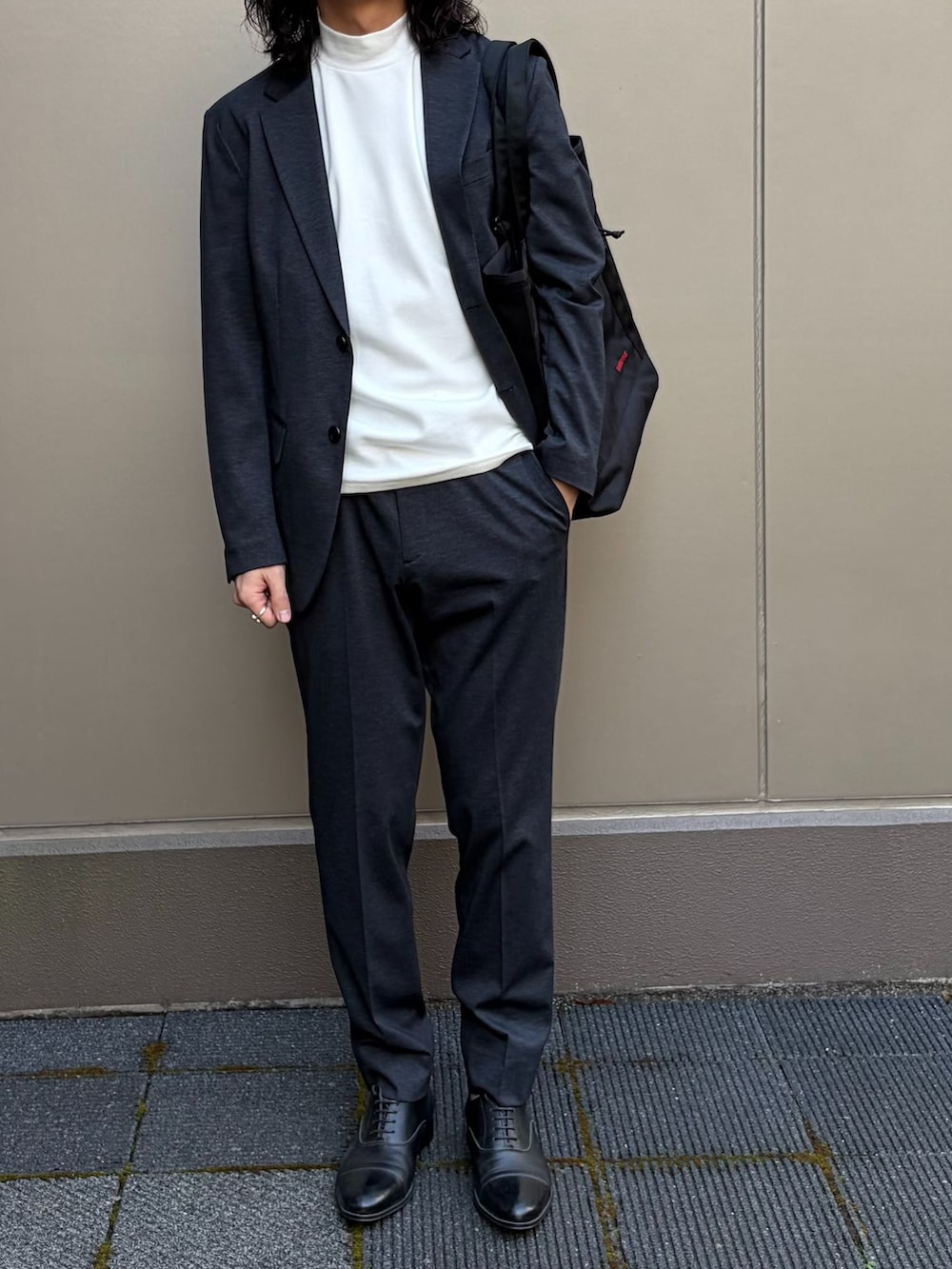 ホワイト系のTシャツ/カットソー、ブラック系のテーラードジャケット、ブラック系のスラックスを着用したメンズの春コーディネートの4枚目の写真