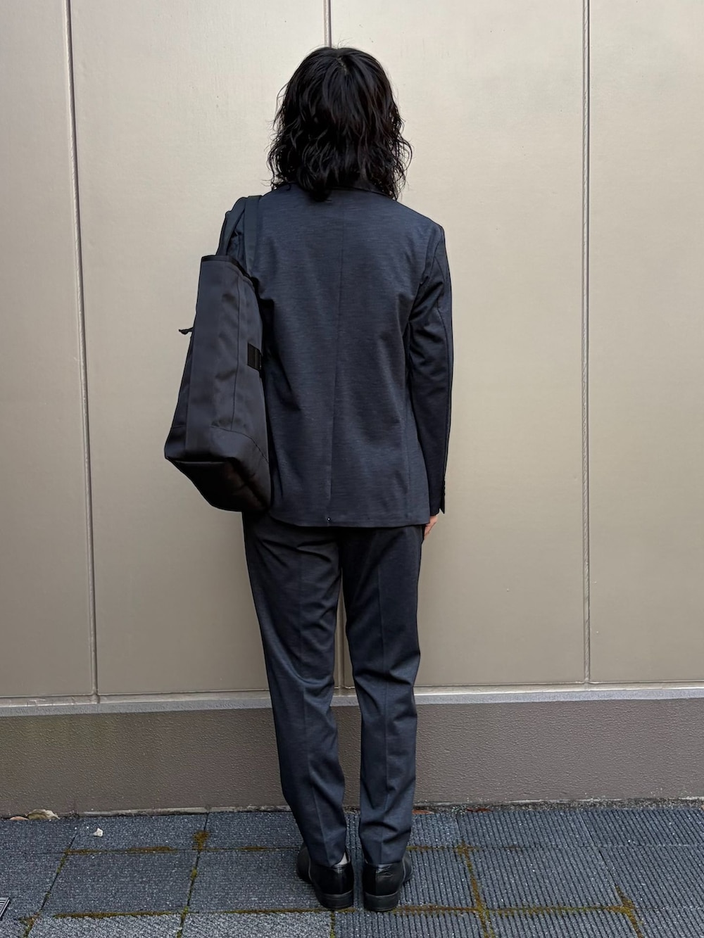 ホワイト系のTシャツ/カットソー、ブラック系のテーラードジャケット、ブラック系のスラックスを着用したメンズの春コーディネートの3枚目の写真