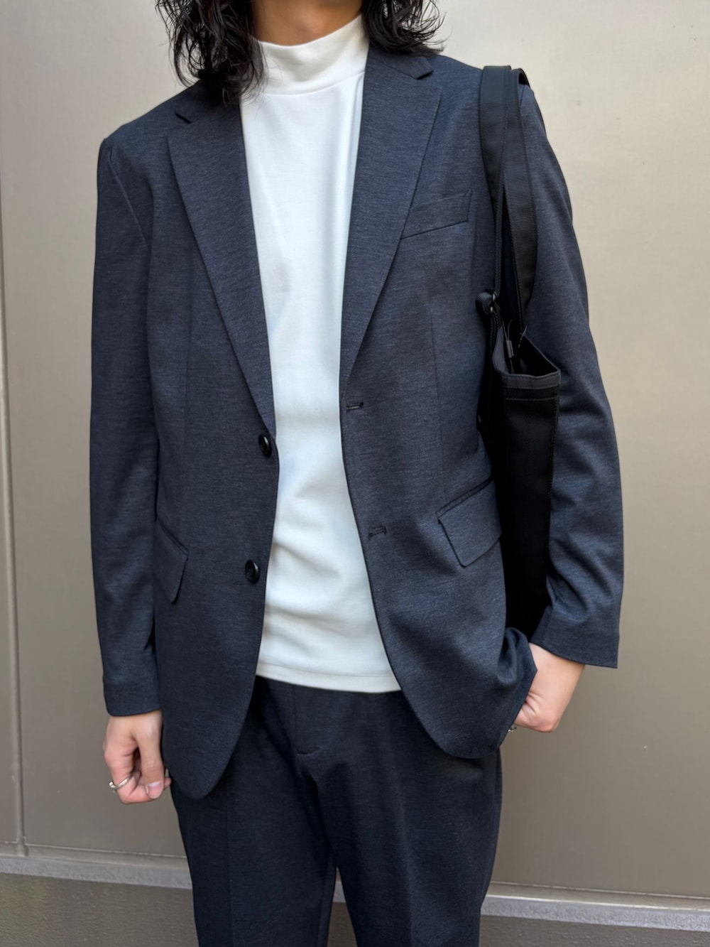 ホワイト系のTシャツ/カットソー、ブラック系のテーラードジャケット、ブラック系のスラックスを着用したメンズの春コーディネートの5枚目の写真