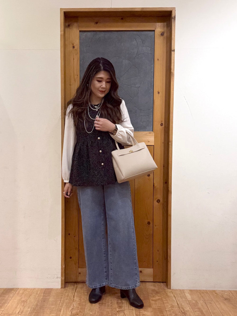 ブラック系のシャツ/ブラウス、ブルー系のデニムパンツを着用したレディースの冬コーディネートの2枚目の写真