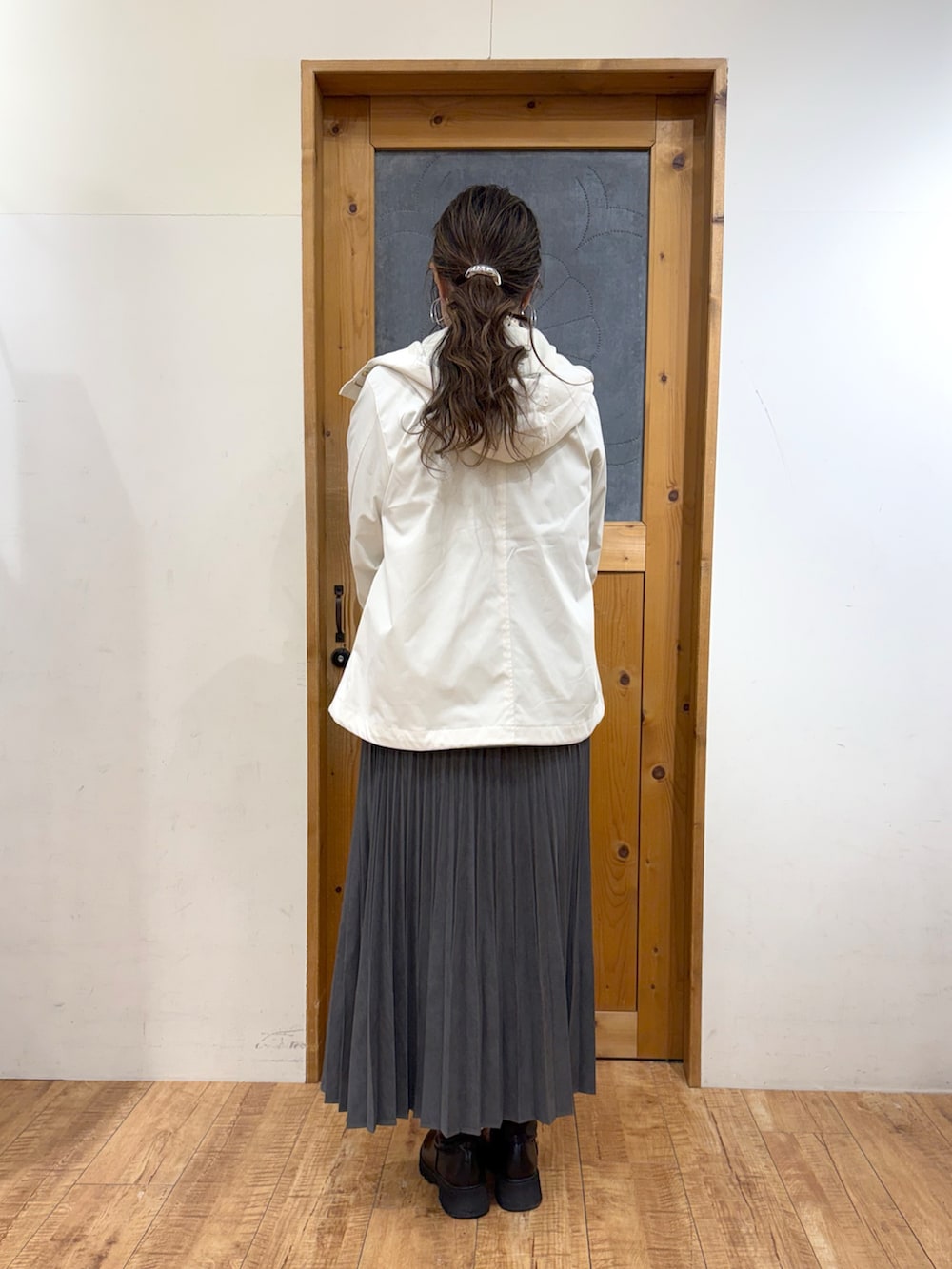 ホワイト系のブルゾン、グリーン系のニット/セーター、グレー系のスカートを着用したレディースの冬コーディネートの5枚目の写真