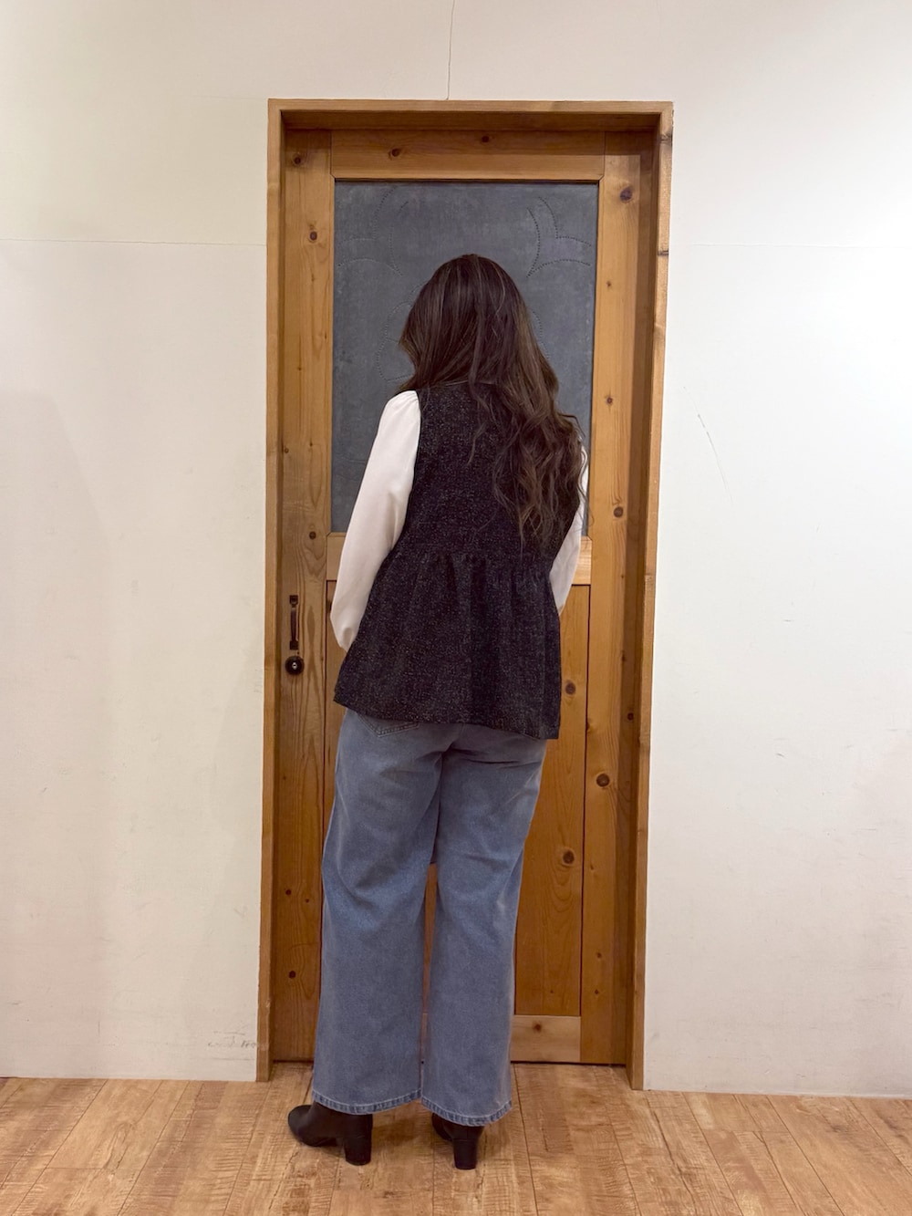 ブラック系のシャツ/ブラウス、ブルー系のデニムパンツを着用したレディースの冬コーディネートの6枚目の写真