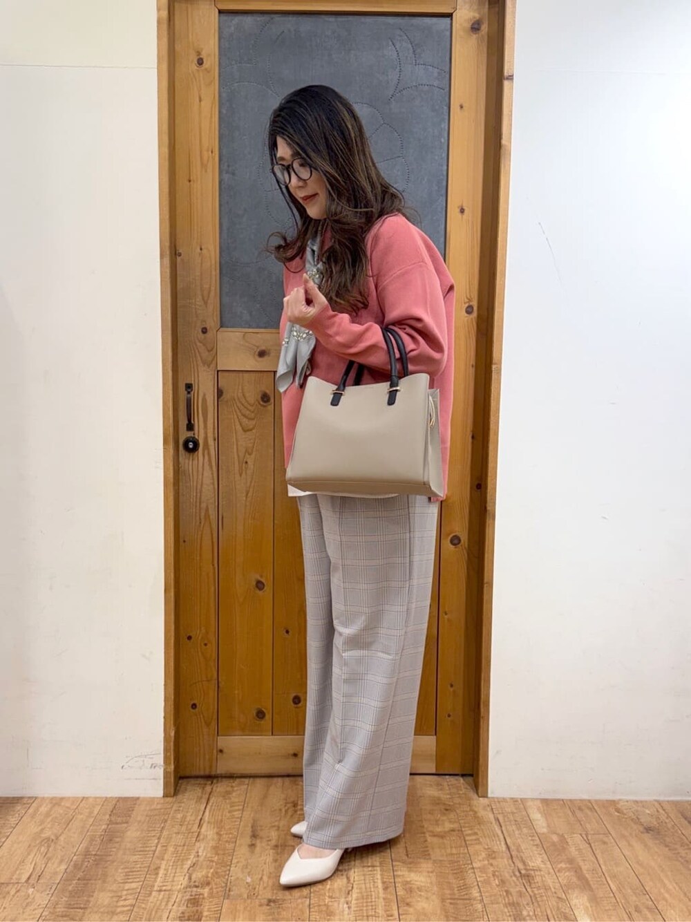 ピンク系のニット/セーター、ブルー系のその他パンツ、ベージュ系のトートバッグを着用したレディースの冬コーディネートの3枚目の写真