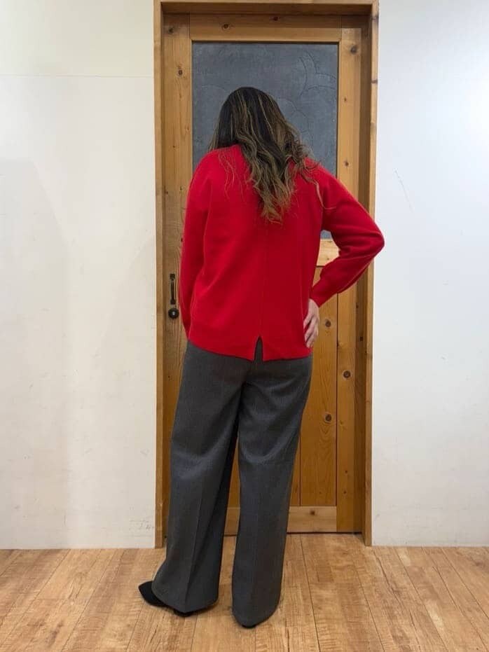 レッド系のニット/セーター、グレー系のその他パンツ、ブラック系のブーツを着用したレディースの秋コーディネートの3枚目の写真