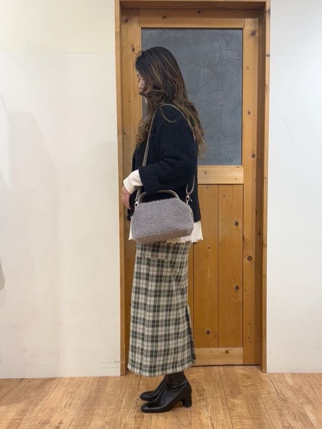 ブルー系のカーディガン/ボレロ、ホワイト系のチュニック、グレー系のスカートを着用したレディースの冬コーディネートの4枚目の写真