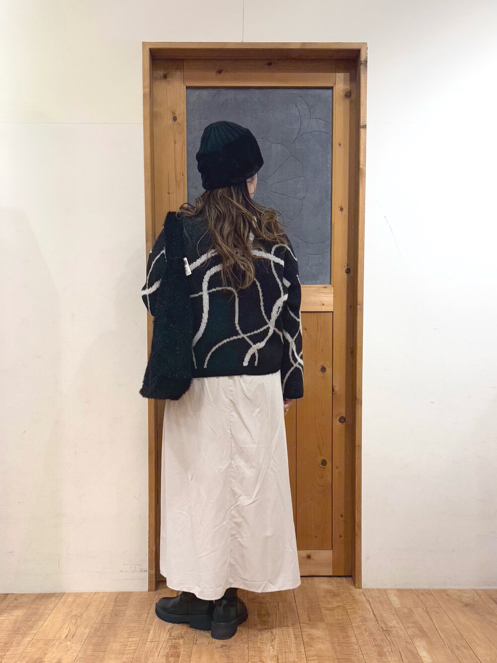 ホワイト系のスカート、ブラック系のトートバッグ、ブラック系のカーディガン/ボレロを着用したレディースの冬コーディネートの6枚目の写真