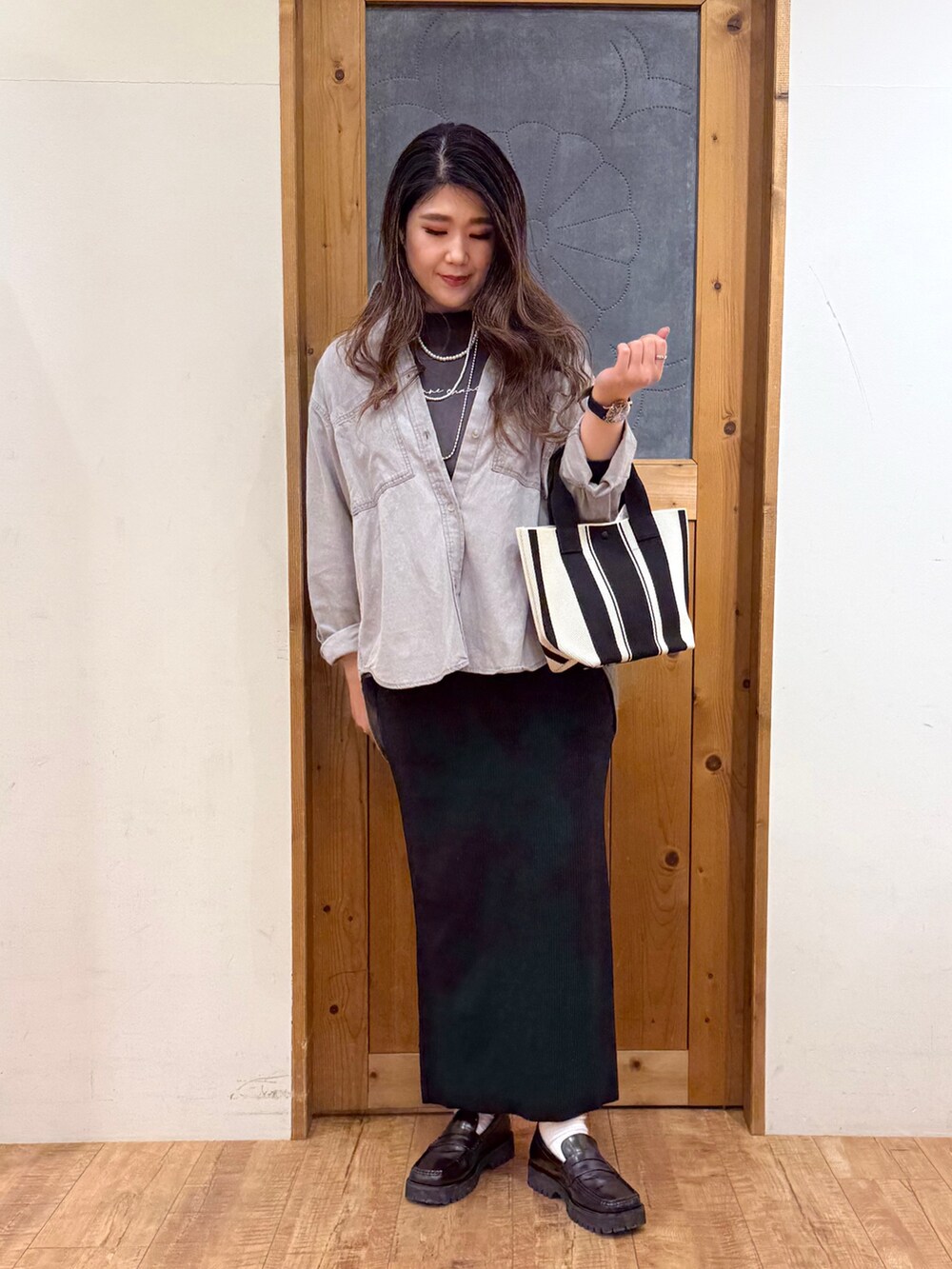 グレー系のシャツ/ブラウス、グレー系のTシャツ/カットソー、ブラック系のスカートを着用したレディースの春コーディネートの2枚目の写真