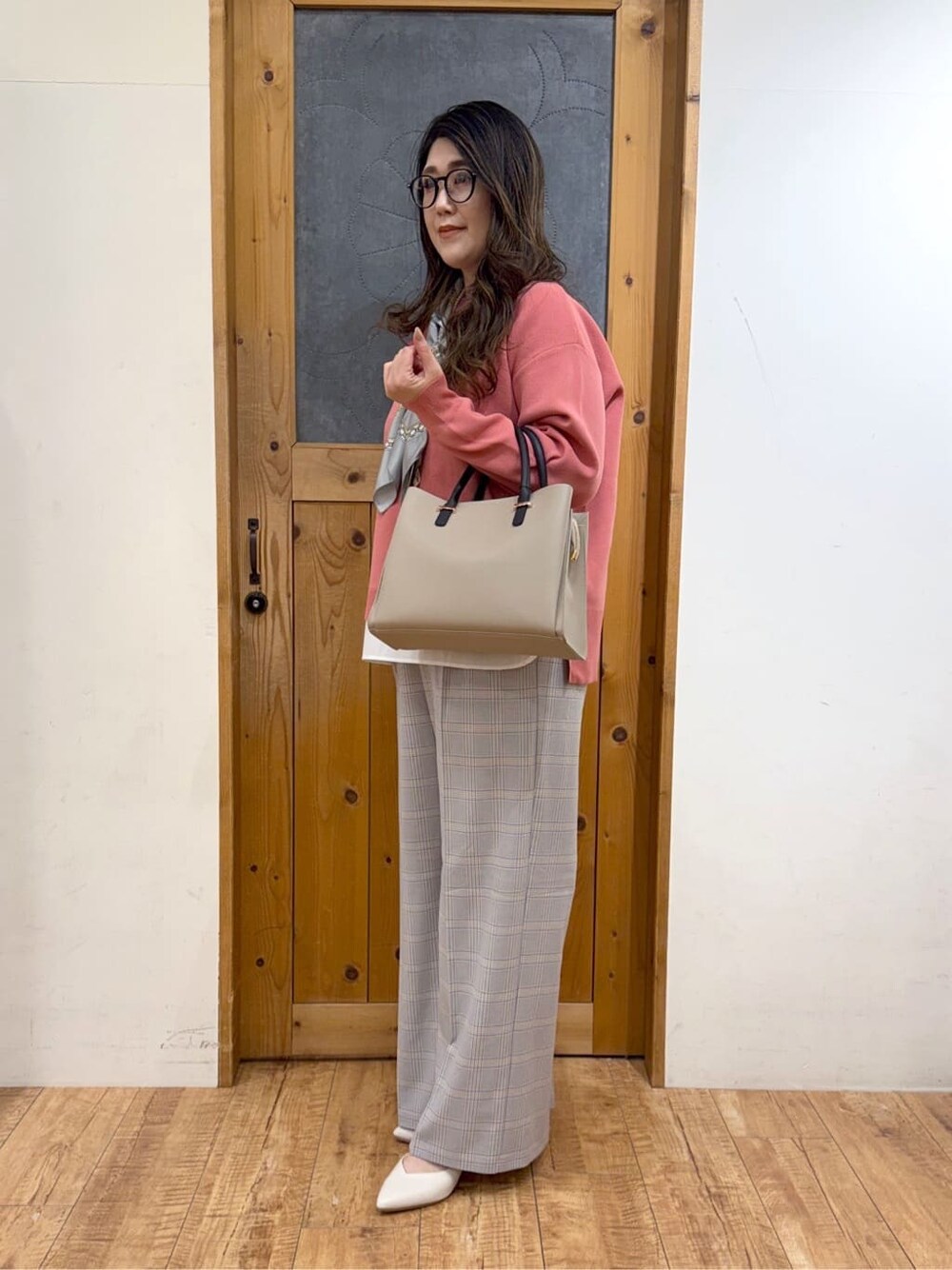 ピンク系のニット/セーター、ブルー系のその他パンツ、ベージュ系のトートバッグを着用したレディースの冬コーディネートの2枚目の写真