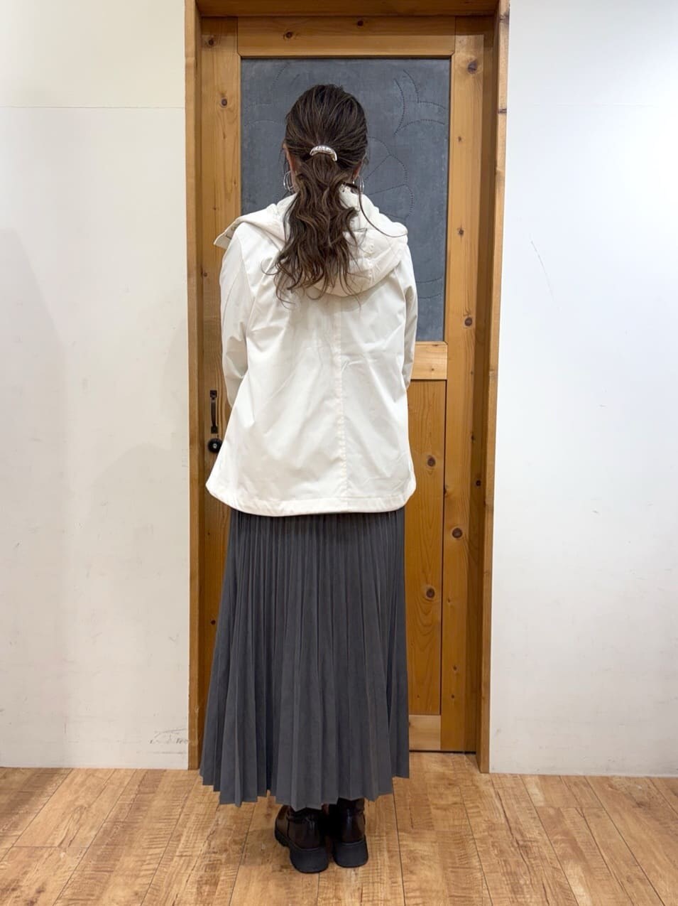 ホワイト系のブルゾン、グリーン系のニット/セーター、グレー系のスカートを着用したレディースの冬コーディネートの5枚目の写真