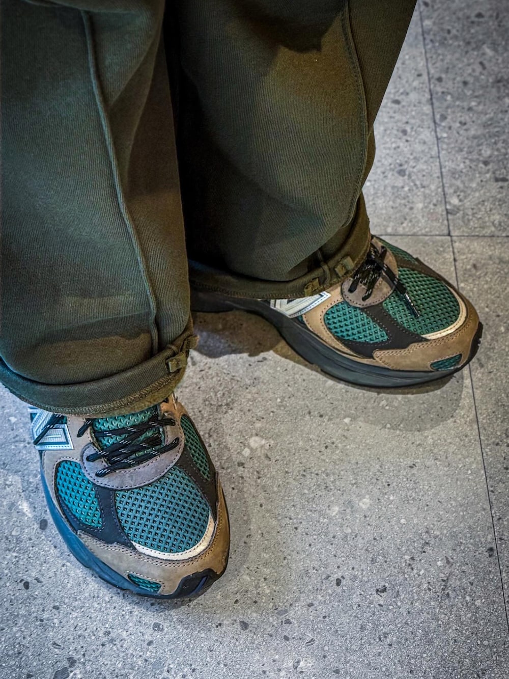 ブラック系のダウンベスト、グリーン系のミリタリージャケット、グリーン系のスウェットパンツを着用したメンズの冬コーディネートの2枚目の写真