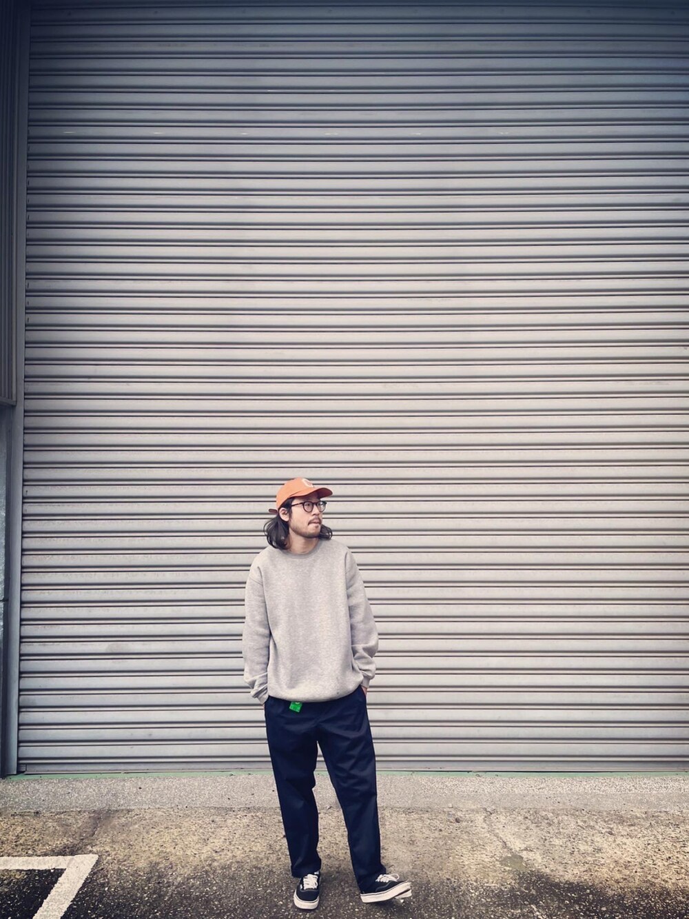 グレー系のトップス、ブルー系のパンツ、ブラック系のシューズを着用したメンズの春コーディネートの2枚目の写真