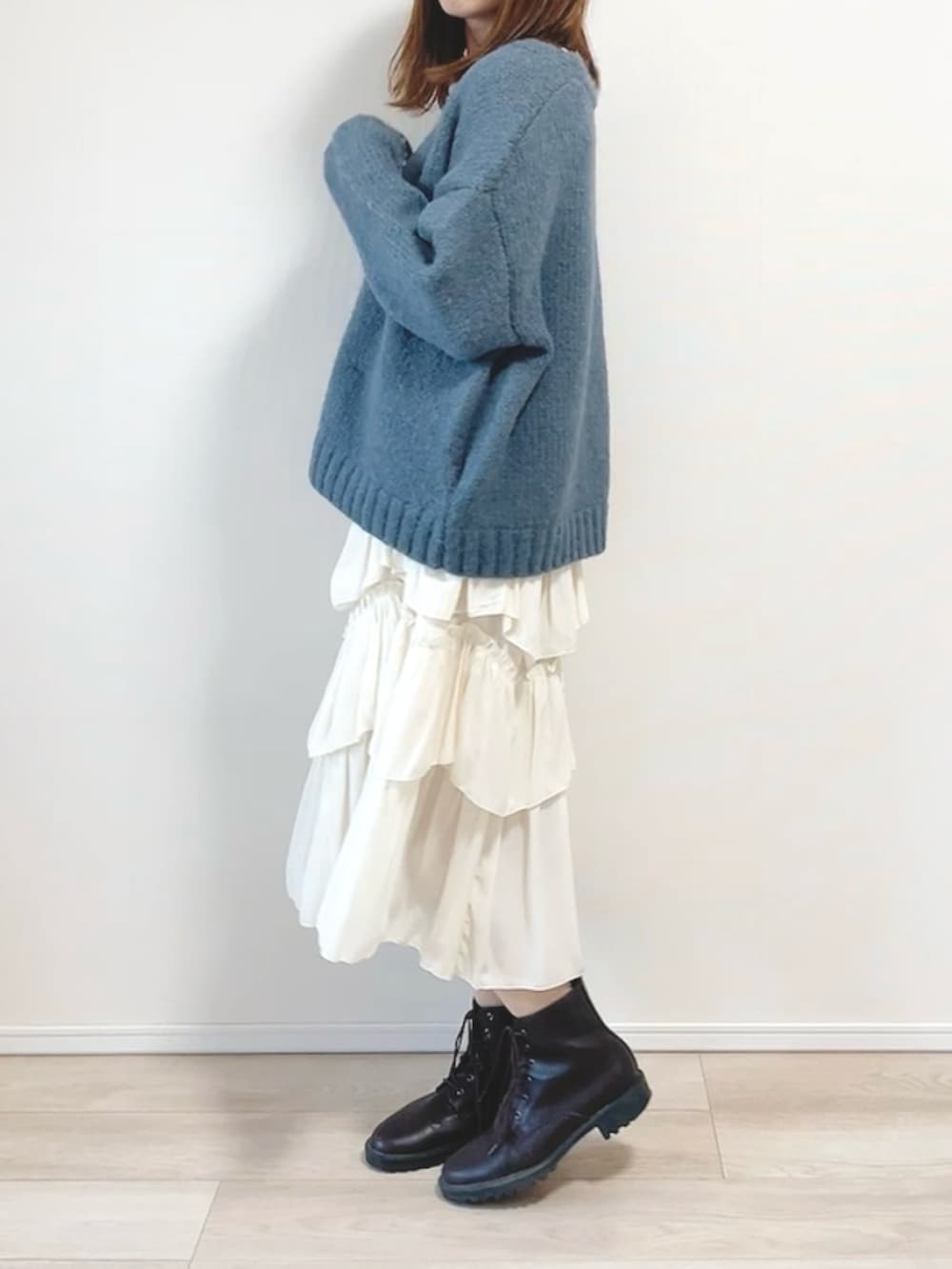 グレー系のカーディガン/ボレロ、ベージュ系のスカート、ブラック系のブーツを着用したレディースの冬コーディネートの2枚目の写真