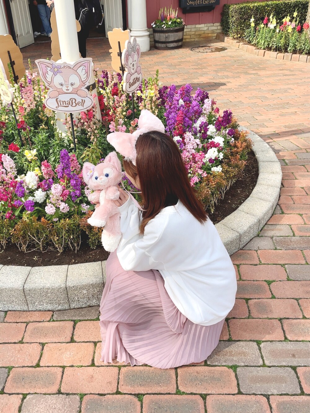 ピンク系のショルダーバッグ、ピンク系のスカート、ホワイト系のスウェットを着用したレディースの春コーディネートの2枚目の写真