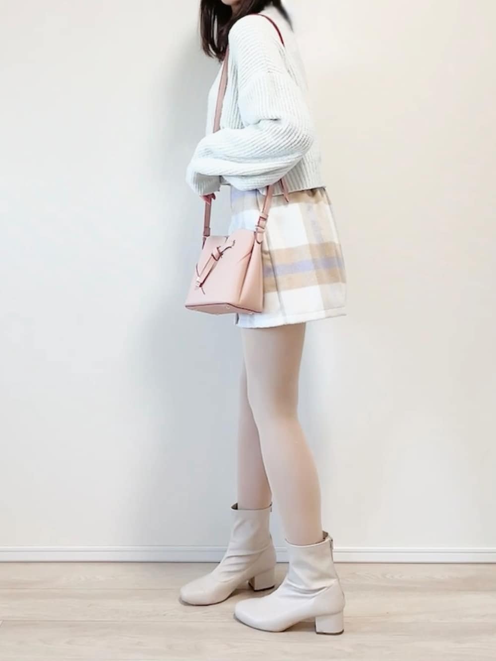 ブルー系のニット/セーター、ピンク系のショルダーバッグ、パープル系のスカートを着用したレディースの冬コーディネートの4枚目の写真