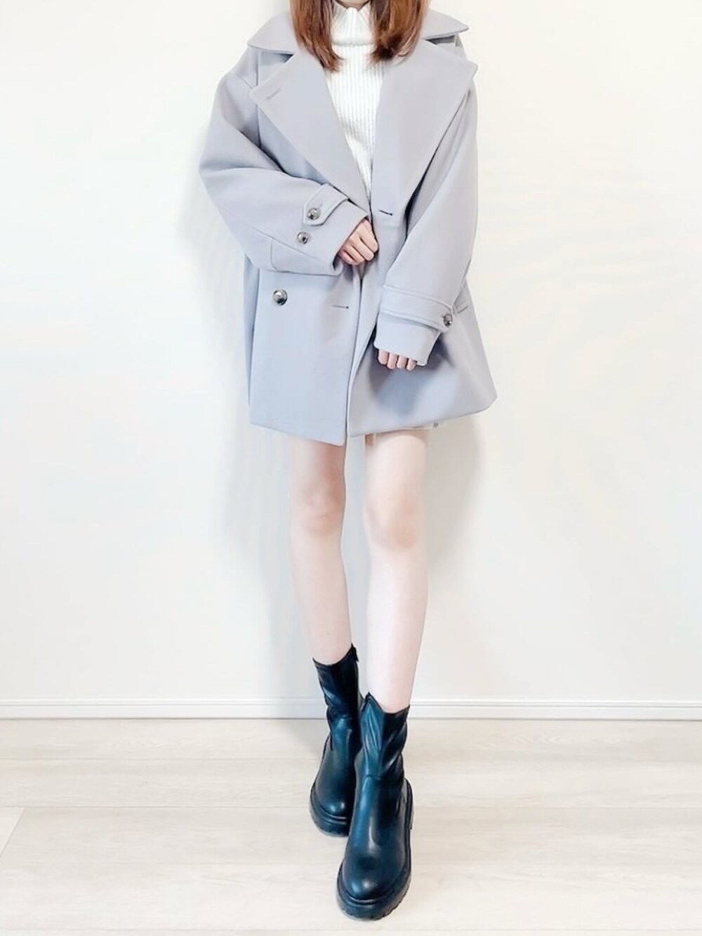 ブルー系のニット/セーター、ブルー系のピーコート、ブラック系のブーツを着用したレディースの冬コーディネートの3枚目の写真