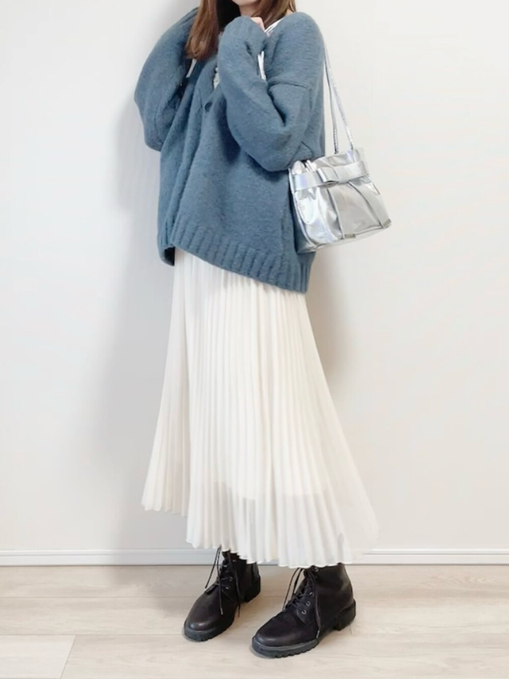 グレー系のカーディガン/ボレロ、シルバー系のショルダーバッグ、ホワイト系のスカートを着用したレディースの冬コーディネートの2枚目の写真