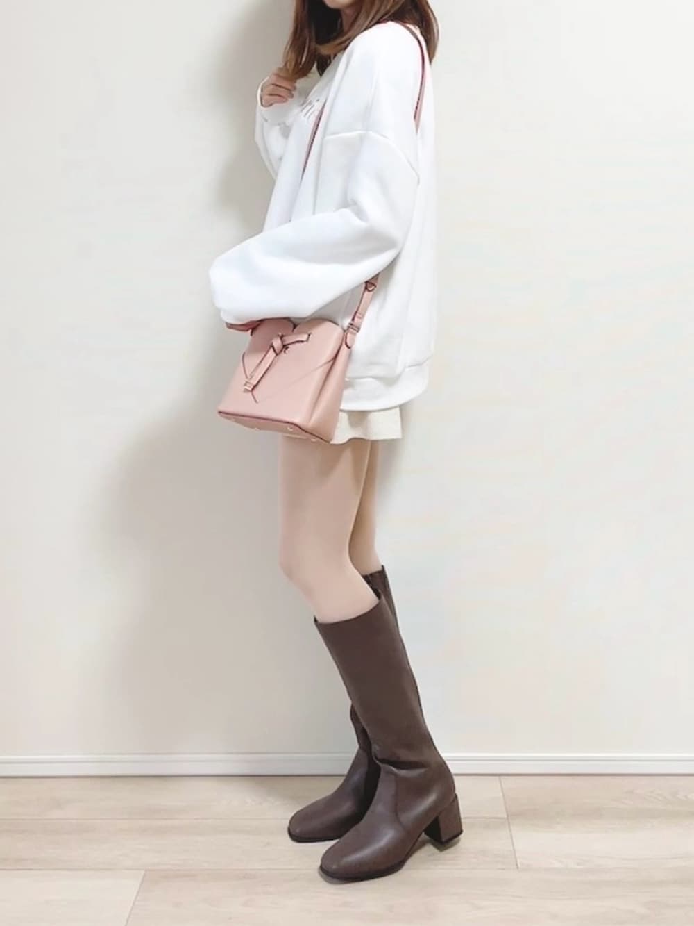 ホワイト系のスウェット、ホワイト系のパンツ、ピンク系のショルダーバッグを着用したレディースの秋コーディネートの4枚目の写真