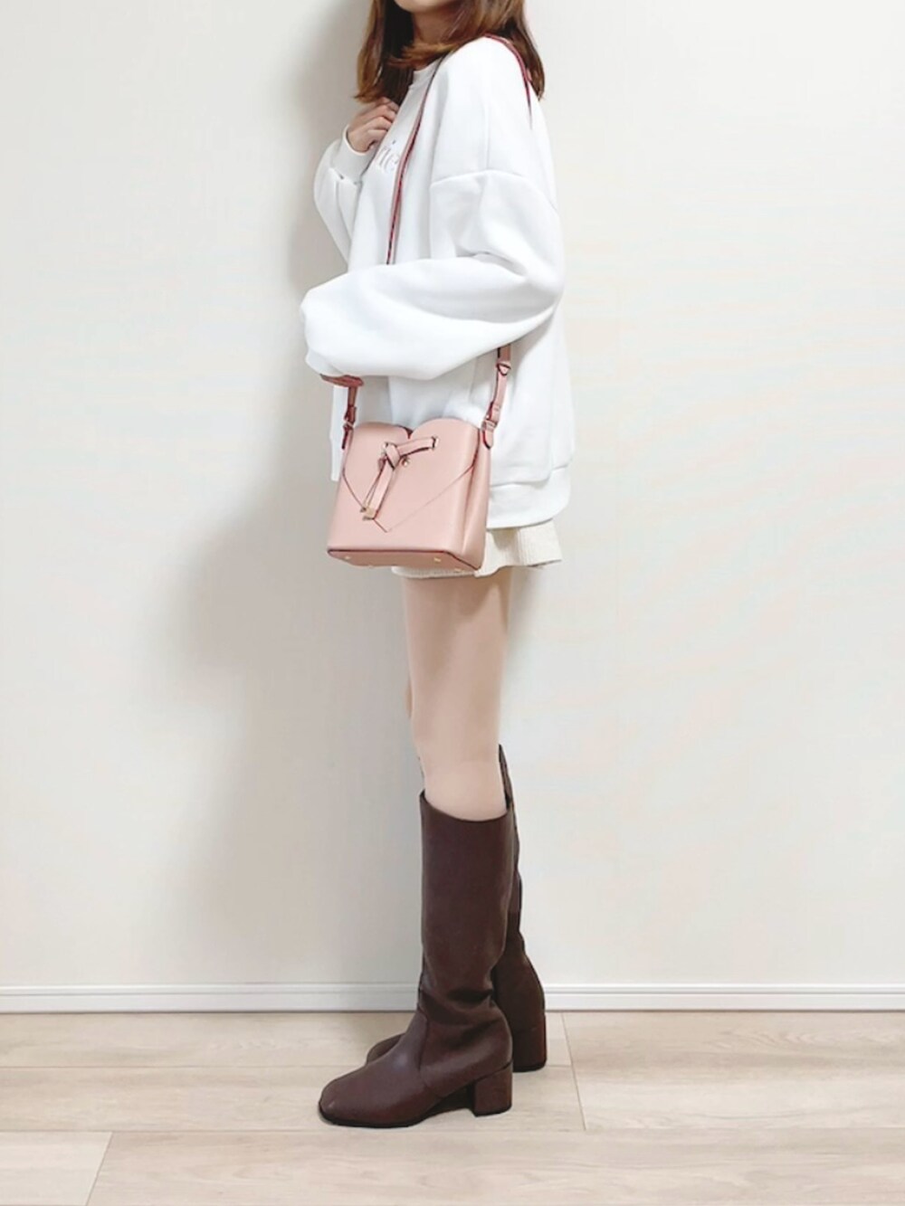 ホワイト系のスウェット、ホワイト系のパンツ、ピンク系のショルダーバッグを着用したレディースの秋コーディネートの5枚目の写真
