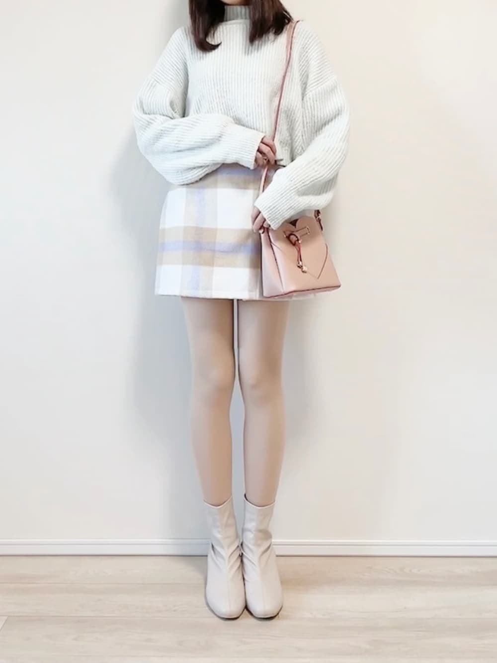 ブルー系のニット/セーター、ピンク系のショルダーバッグ、パープル系のスカートを着用したレディースの冬コーディネートの3枚目の写真