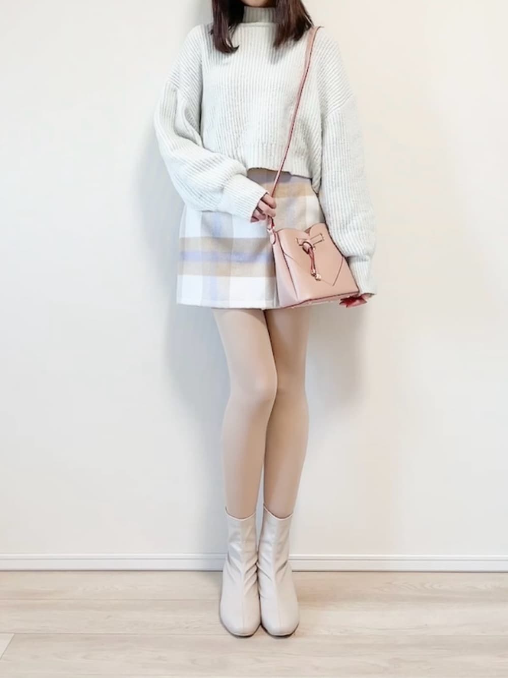 ブルー系のニット/セーター、ピンク系のショルダーバッグ、パープル系のスカートを着用したレディースの冬コーディネートの2枚目の写真