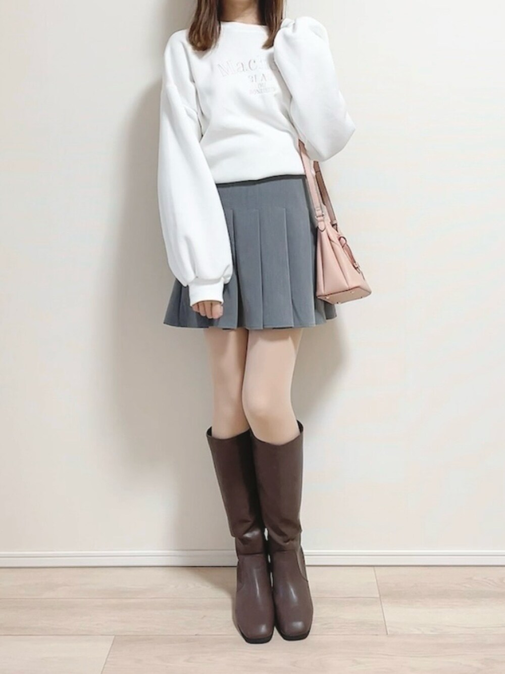 ホワイト系のスウェット、ピンク系のショルダーバッグ、グレー系のスカートを着用したレディースの冬コーディネートの3枚目の写真