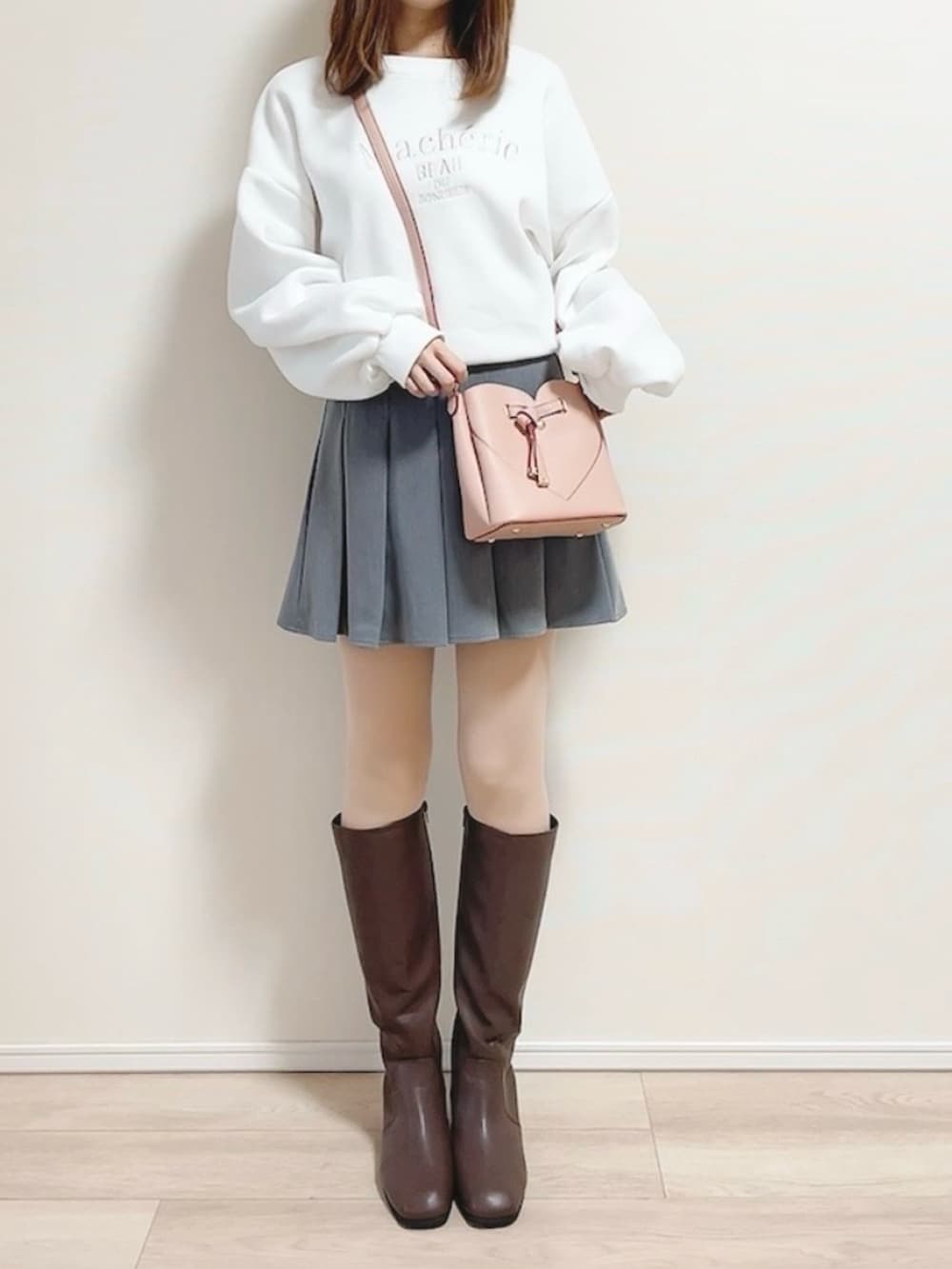 ホワイト系のスウェット、ピンク系のショルダーバッグ、グレー系のスカートを着用したレディースの冬コーディネートの4枚目の写真