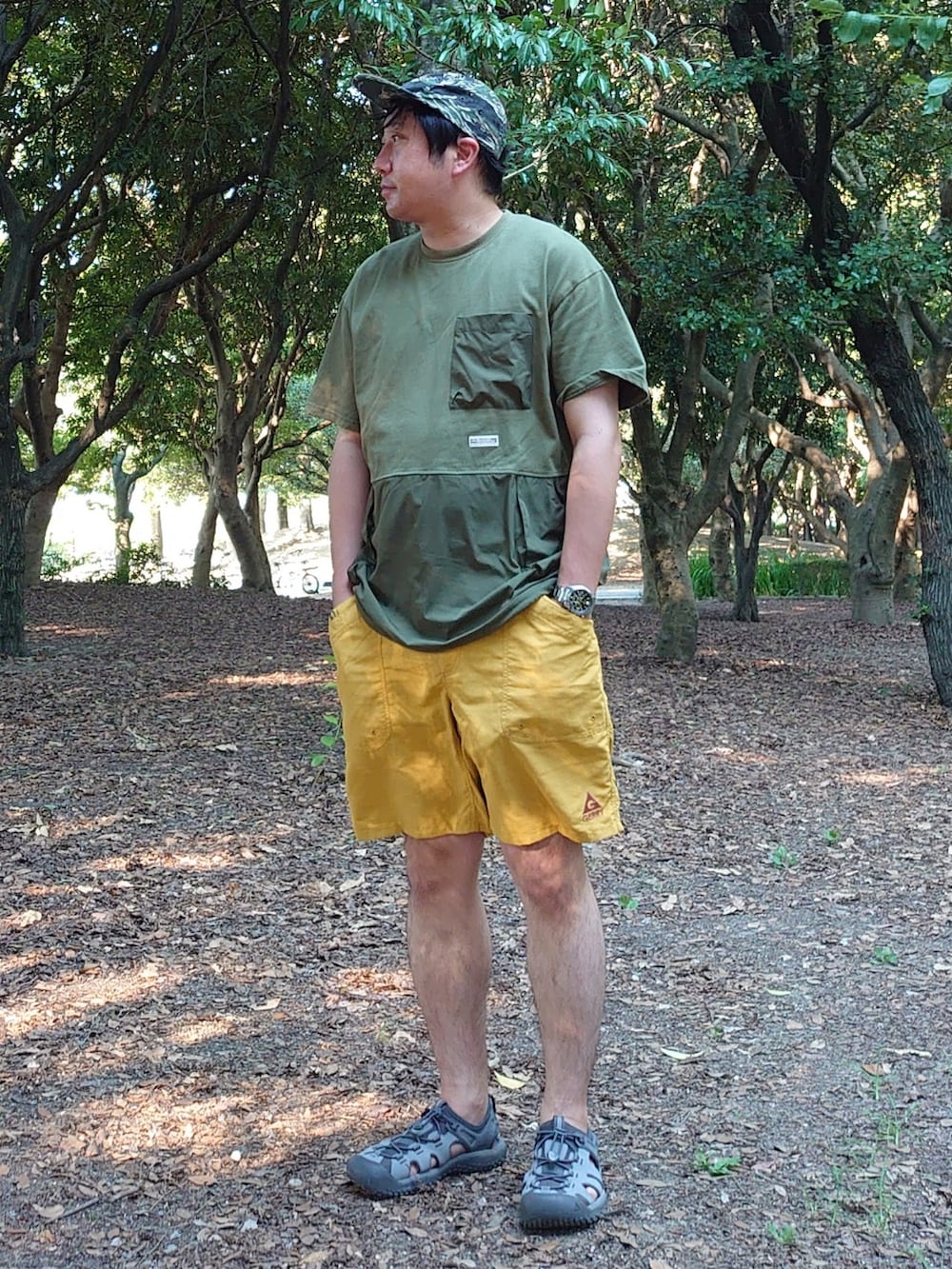 グリーン系のTシャツ/カットソー、イエロー系のその他パンツ、グレー系のサンダルを着用したメンズの夏コーディネートの2枚目の写真