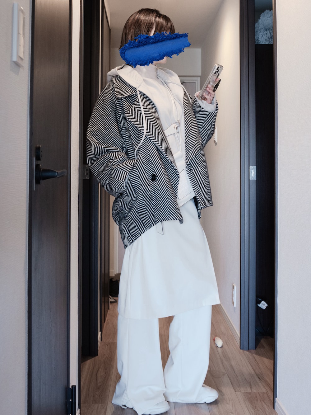 ホワイト系のショルダーバッグ、ベージュ系のニット/セーター、ブラック系のテーラードジャケットを着用したレディースの春コーディネートの2枚目の写真