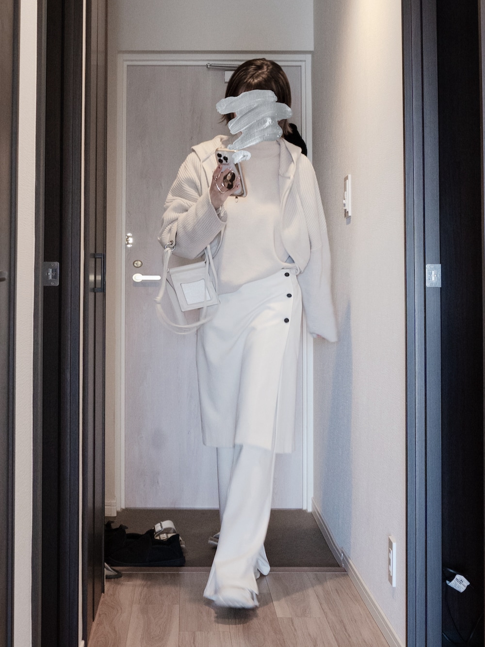 ホワイト系のショルダーバッグ、ベージュ系のニット/セーター、ブラック系のテーラードジャケットを着用したレディースの春コーディネートの4枚目の写真