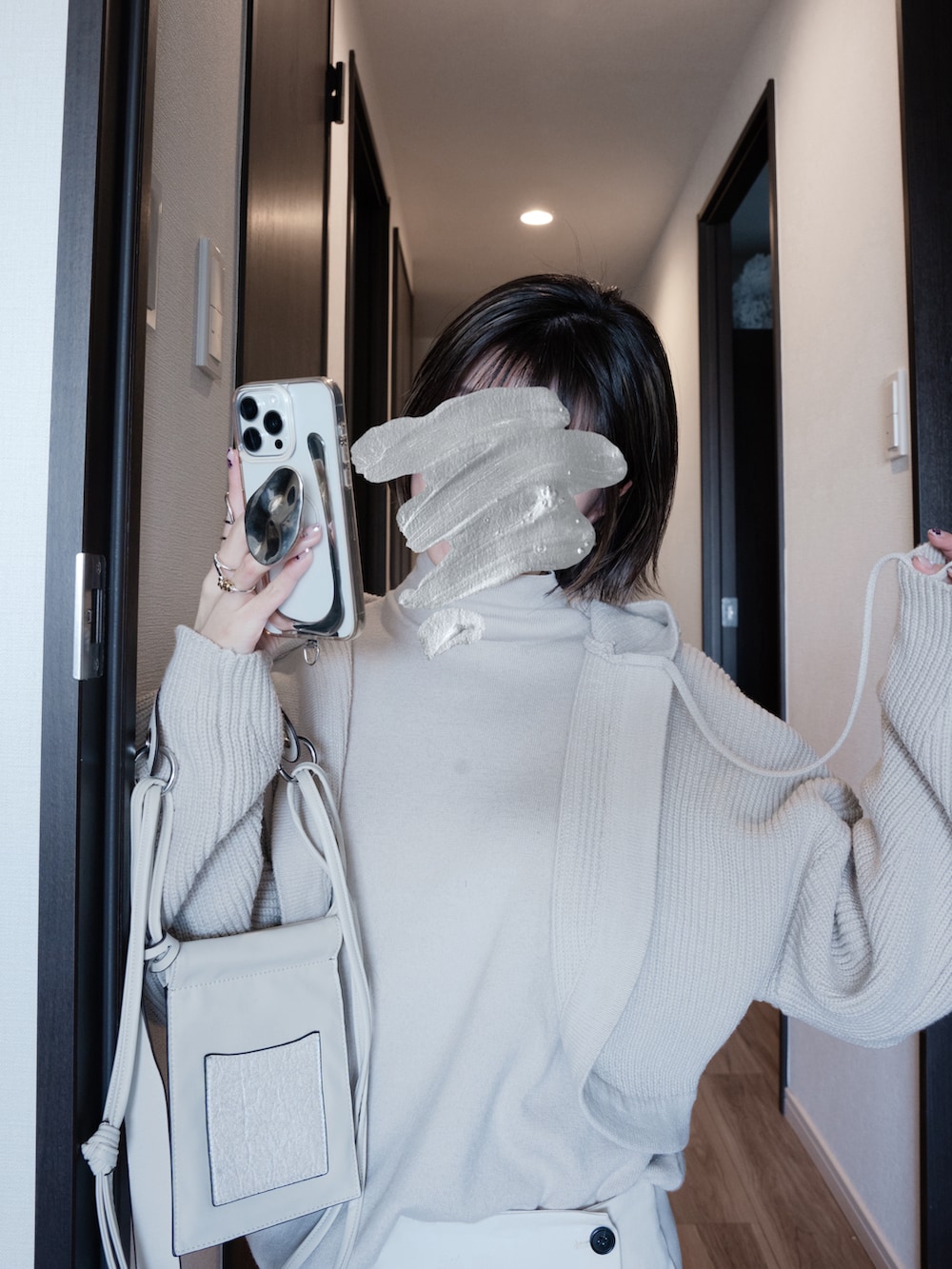 ホワイト系のショルダーバッグ、ベージュ系のニット/セーター、ブラック系のテーラードジャケットを着用したレディースの春コーディネートの3枚目の写真