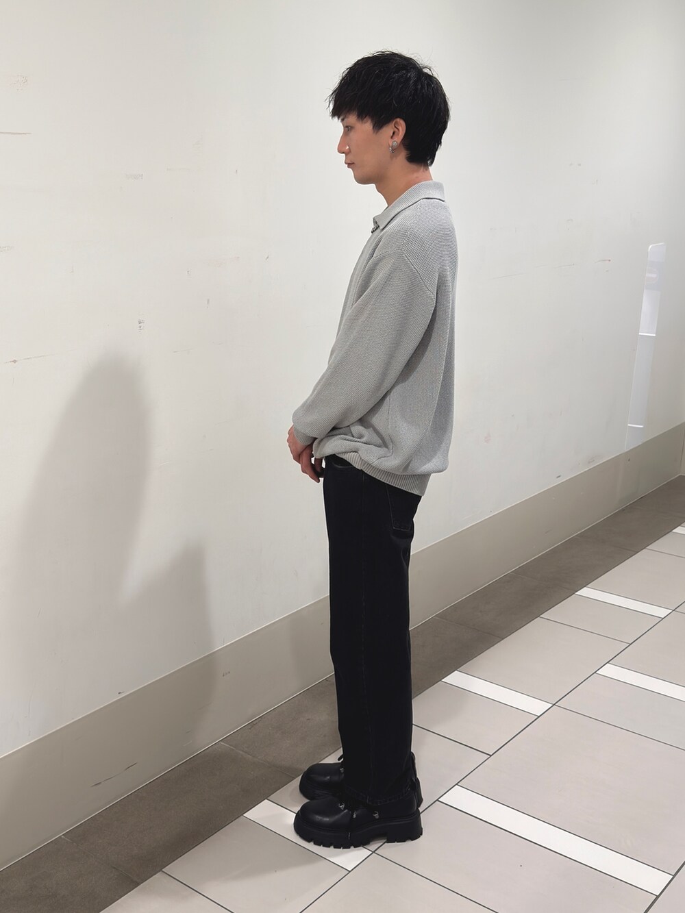 グレー系のニット/セーター、ブラック系のデニムパンツを着用したメンズの冬コーディネートの2枚目の写真