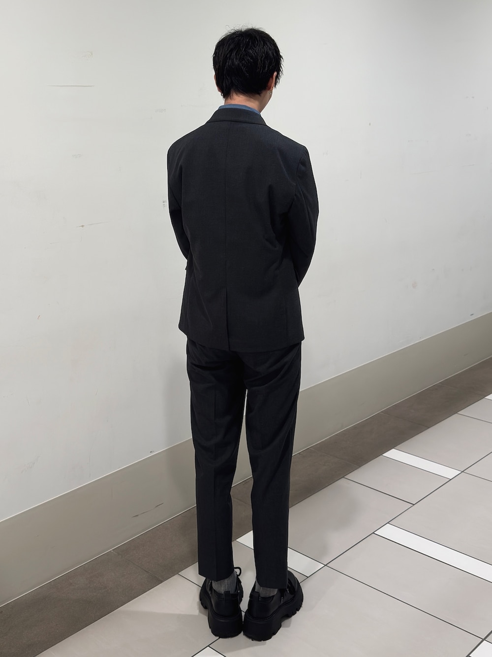 グレー系のその他アウター、グレー系のスーツパンツ、ブルー系のネクタイを着用したメンズの春コーディネートの3枚目の写真