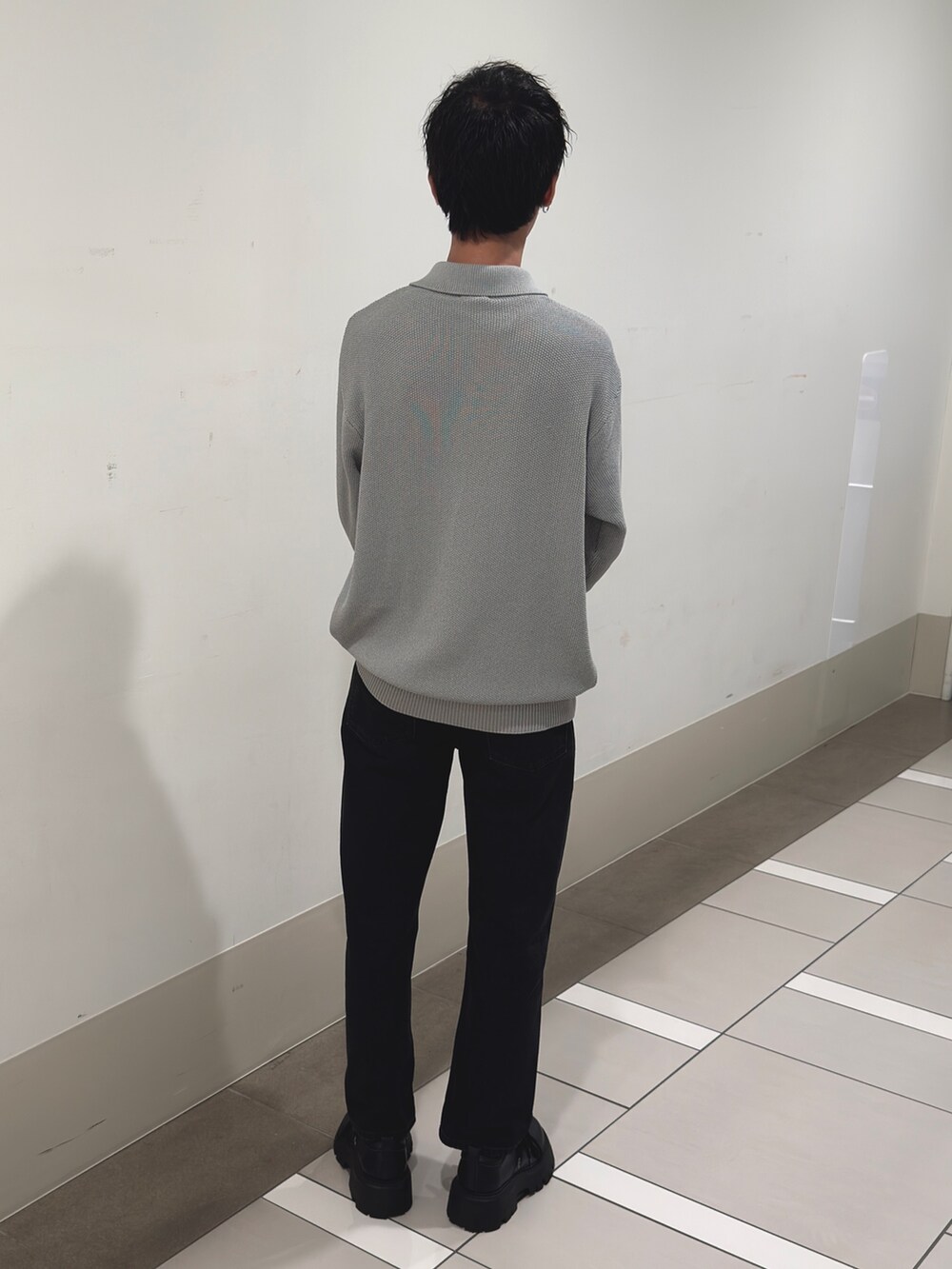 グレー系のニット/セーター、ブラック系のデニムパンツを着用したメンズの冬コーディネートの3枚目の写真