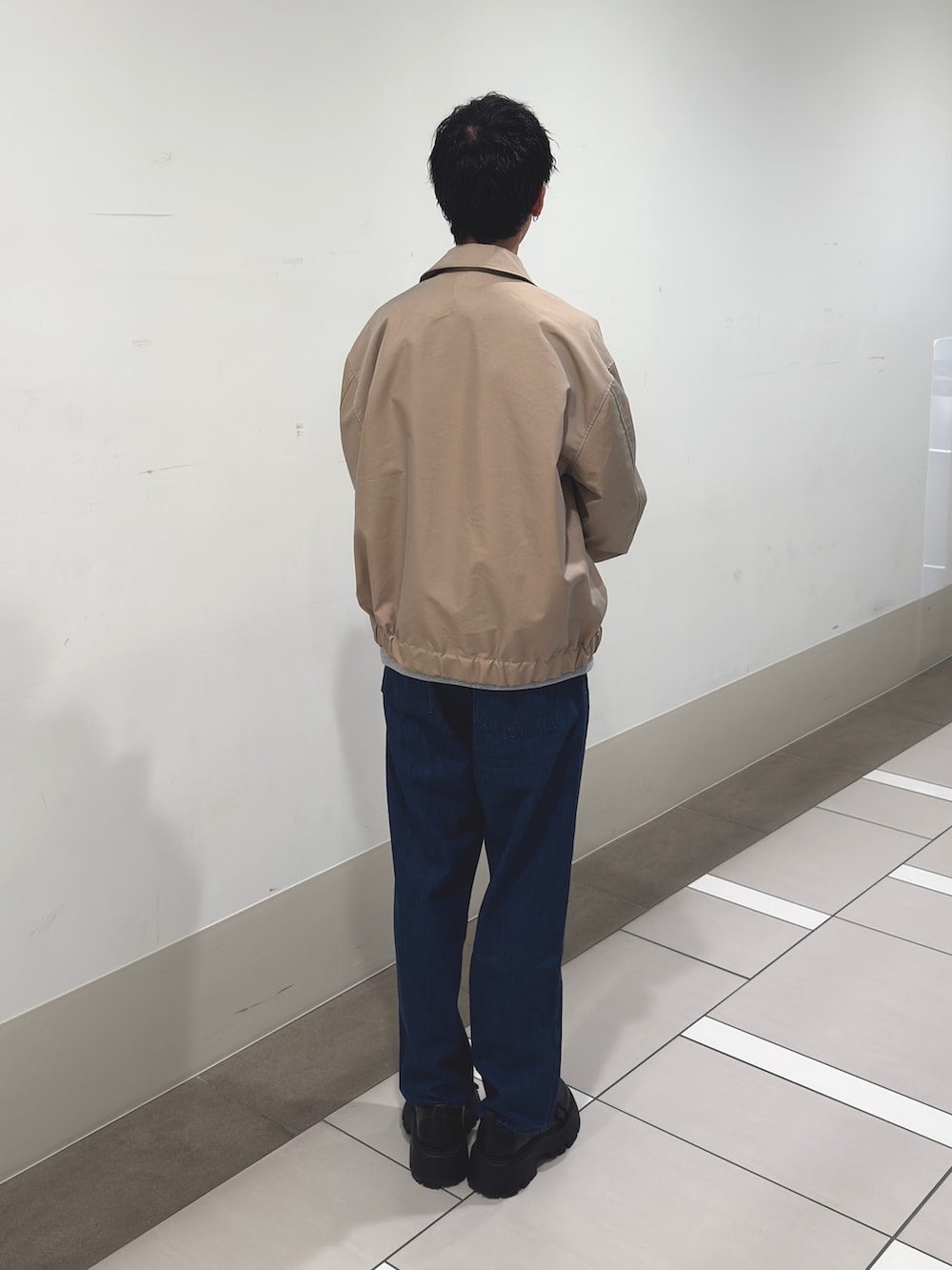 ベージュ系のブルゾン、グレー系のスウェット、ブルー系のデニムパンツを着用したメンズの冬コーディネートの3枚目の写真