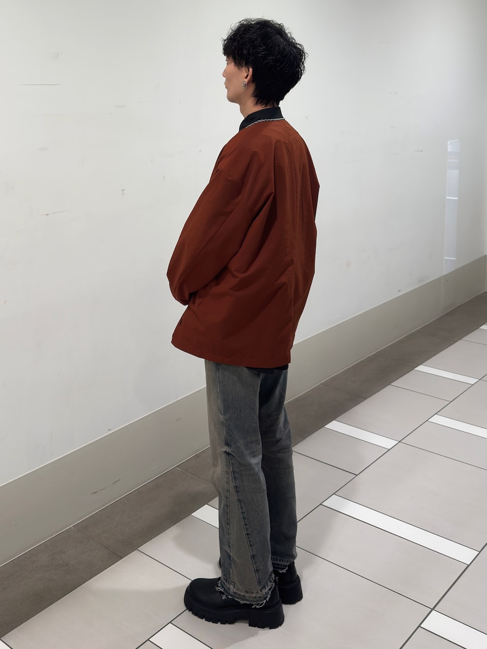 オレンジ系のカーディガン/ボレロ、ブラック系のシャツ/ブラウスを着用したメンズの春コーディネートの2枚目の写真