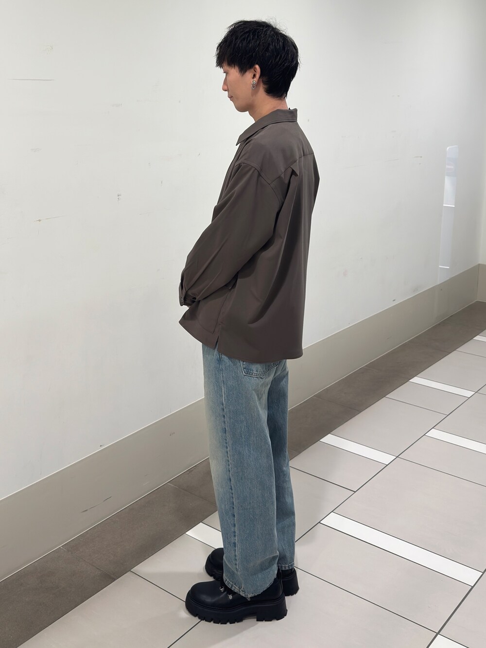 ブラウン系のその他アウター、グレー系のニット/セーター、ブルー系のデニムパンツを着用したメンズの冬コーディネートの2枚目の写真