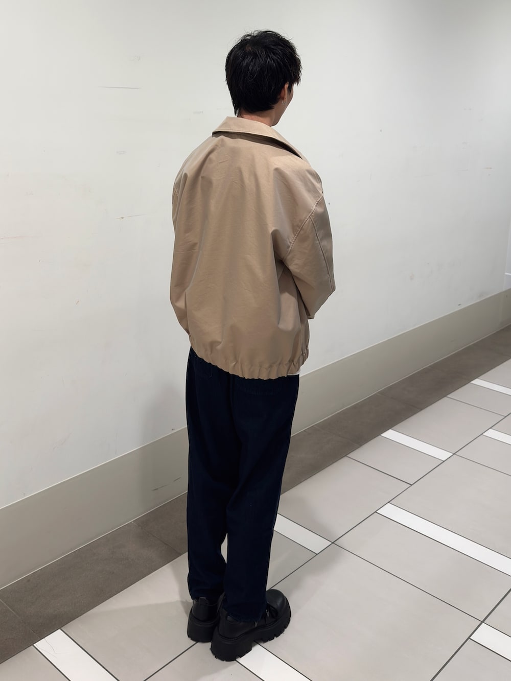 ベージュ系のブルゾン、グレー系のスウェット、ブルー系のデニムパンツを着用したメンズの春コーディネートの3枚目の写真