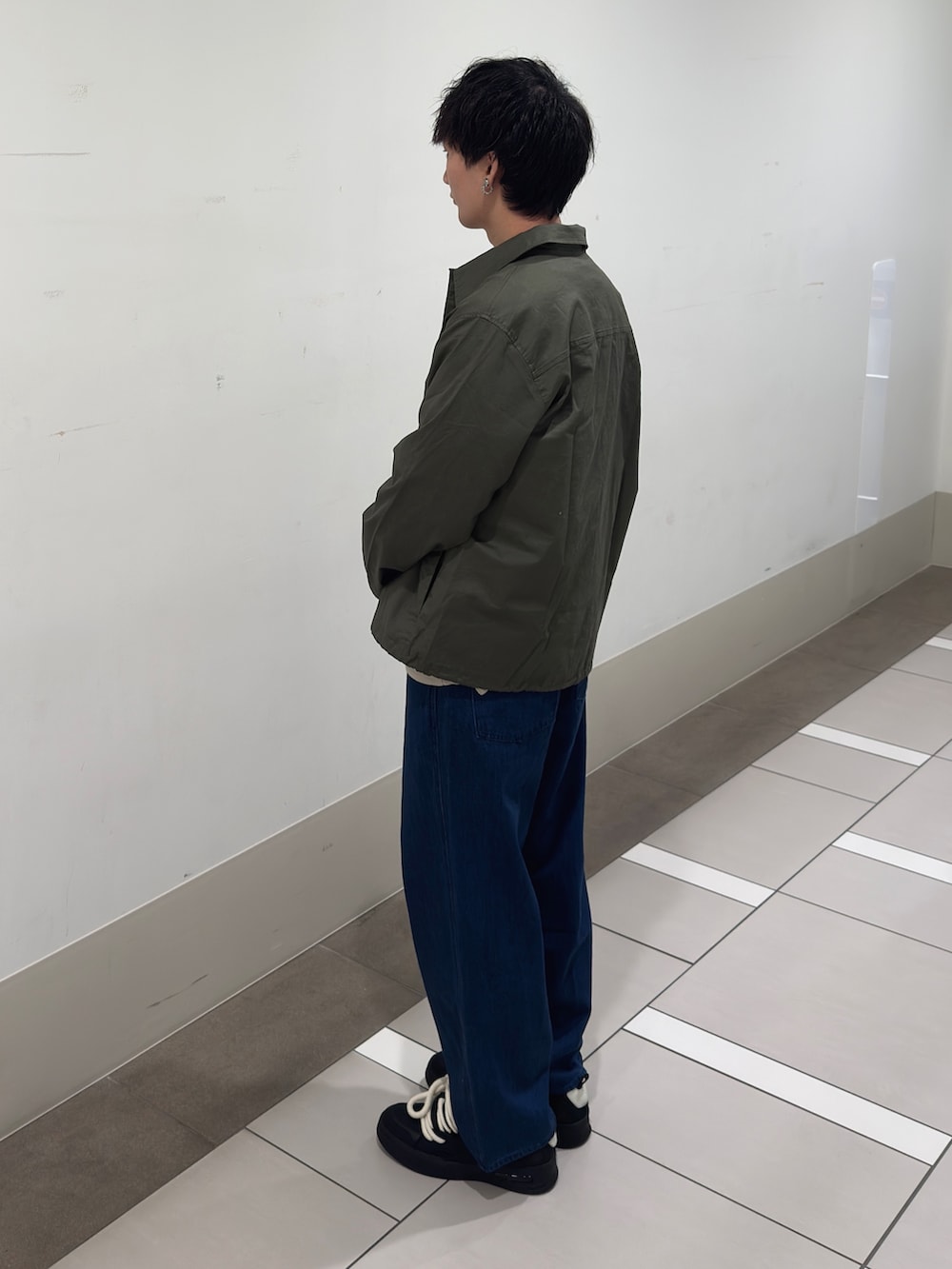 グレー系のカーディガン/ボレロ、ブルー系のデニムパンツを着用したメンズの春コーディネートの2枚目の写真