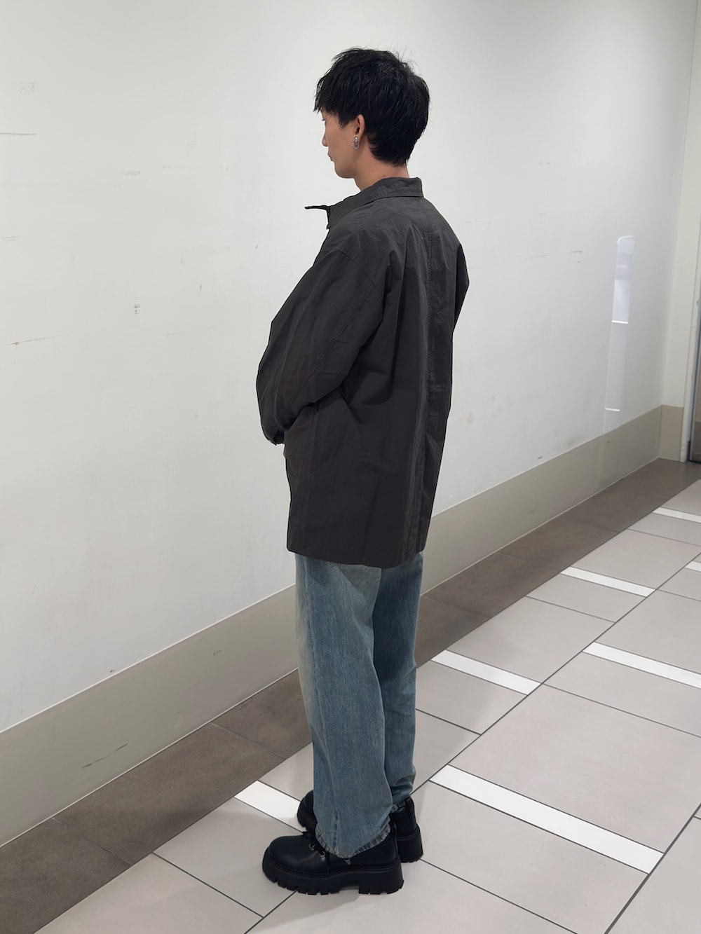 グレー系のカバーオール、ブルー系のTシャツ/カットソー、ブルー系のデニムパンツを着用したメンズの冬コーディネートの2枚目の写真