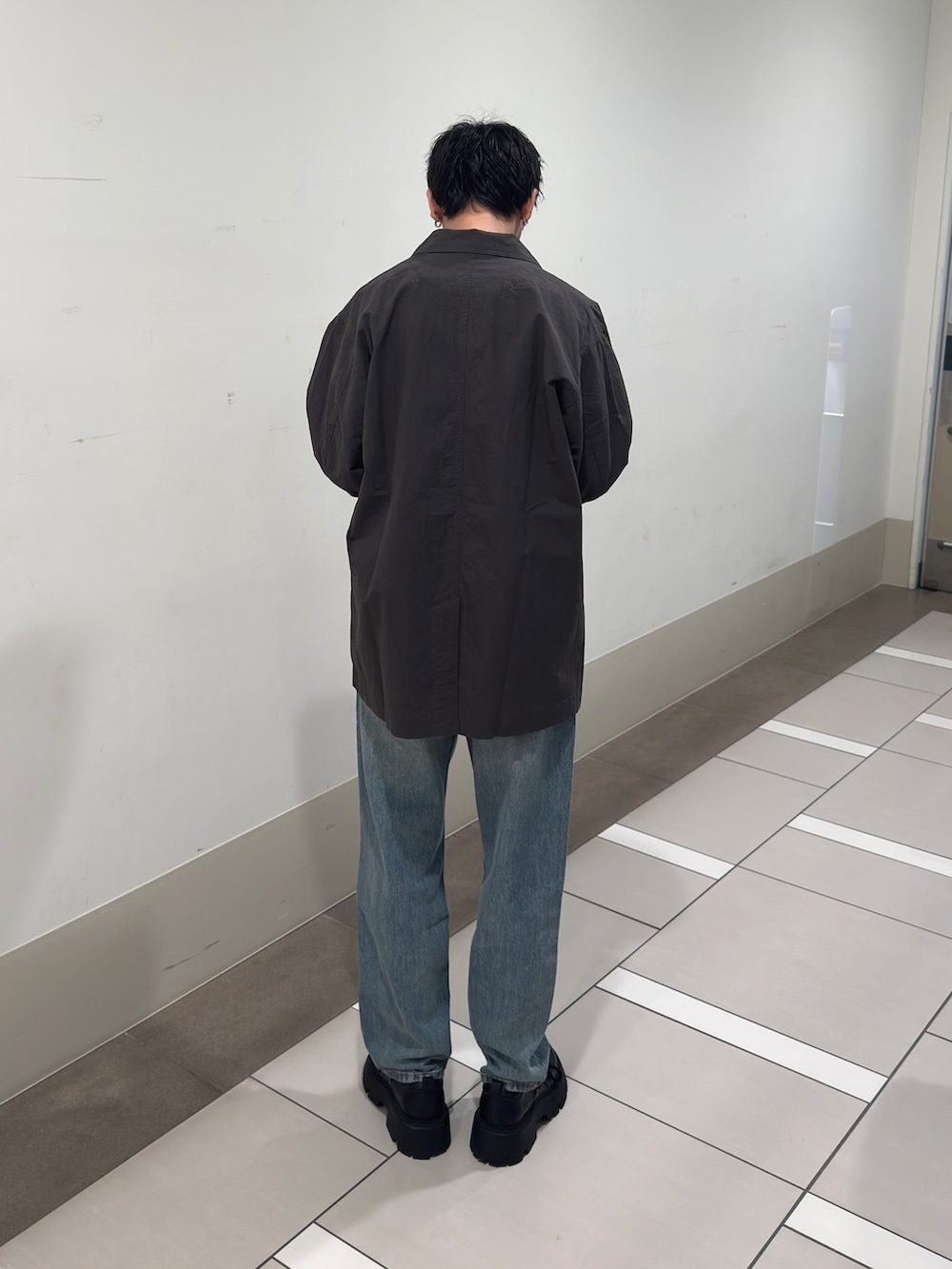 グレー系のカバーオール、ブルー系のTシャツ/カットソー、ブルー系のデニムパンツを着用したメンズの冬コーディネートの3枚目の写真