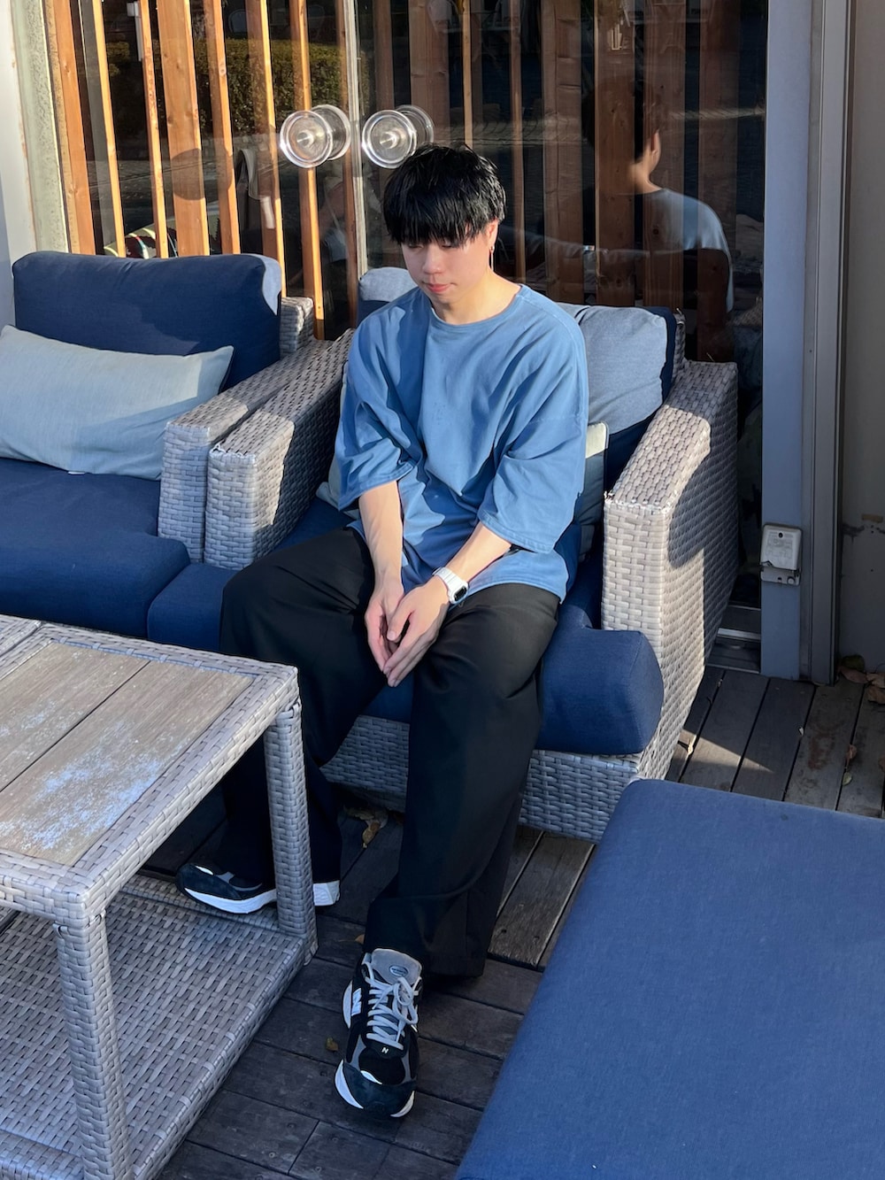 ブルー系のTシャツ/カットソー、ブラック系のスラックス、ブラック系のスニーカーを着用したメンズの夏コーディネートの3枚目の写真