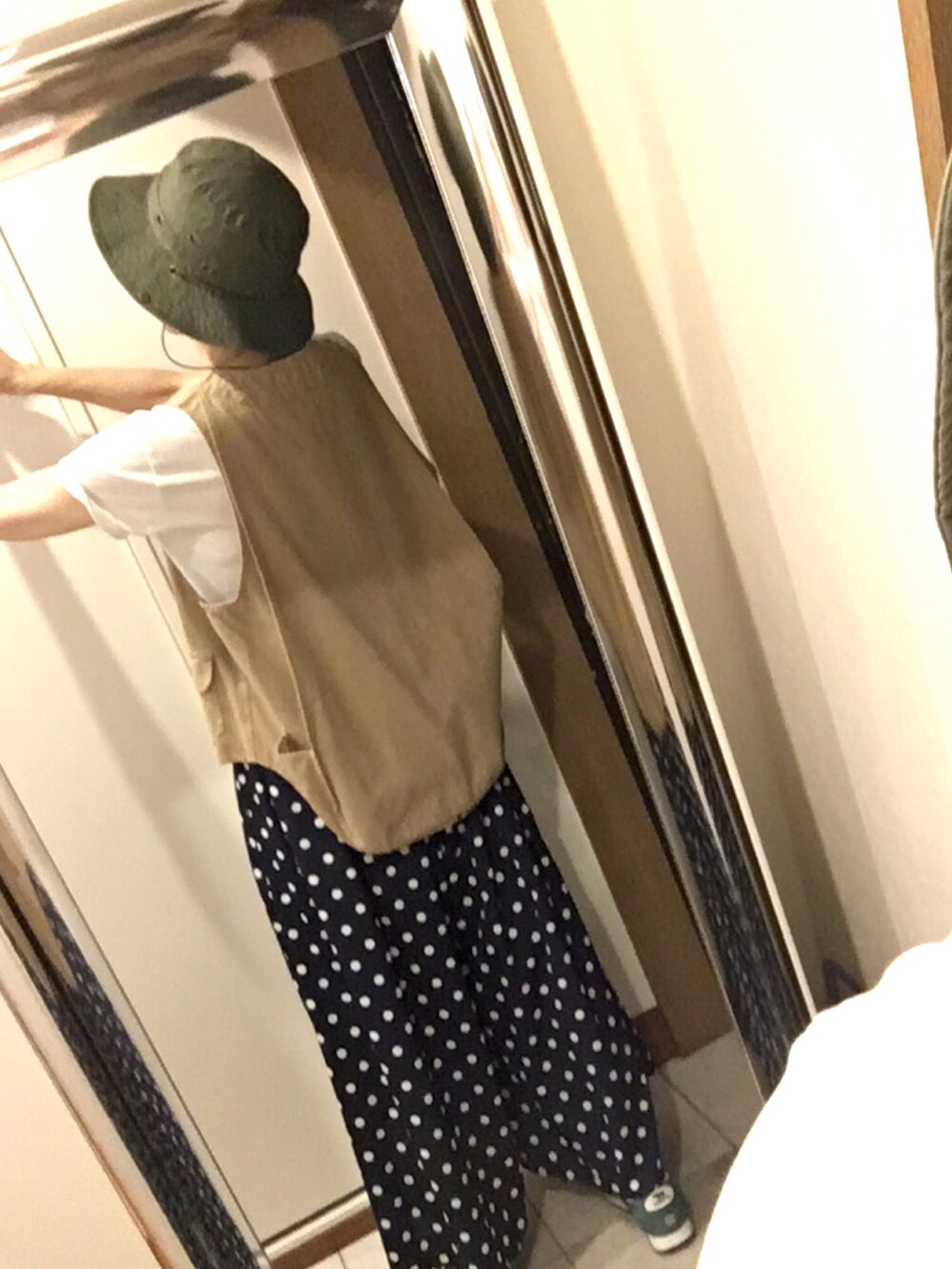 ホワイト系のTシャツ/カットソー、ベージュ系のベスト、グリーン系のスニーカーを着用したレディースの夏コーディネートの5枚目の写真