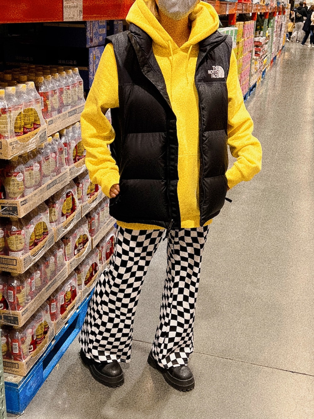 ブラック系のダウンベスト、その他のその他パンツ、イエロー系のパーカーを着用したレディースの冬コーディネートの2枚目の写真