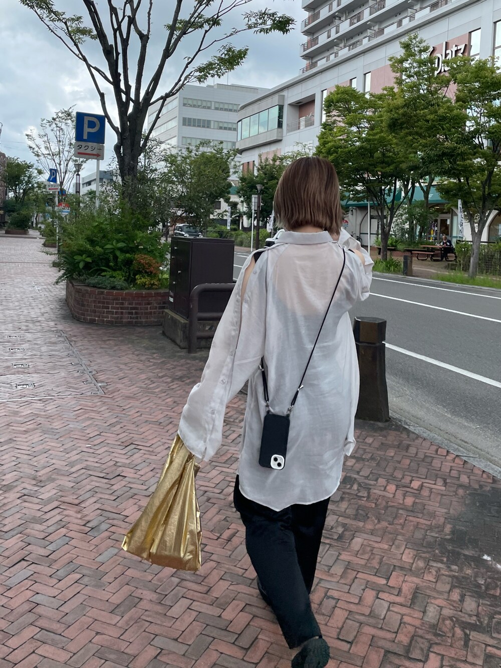 ホワイト系のシャツ/ブラウス、ブラック系のサンダル、ブラック系のスラックスを着用したレディースの夏コーディネートの2枚目の写真