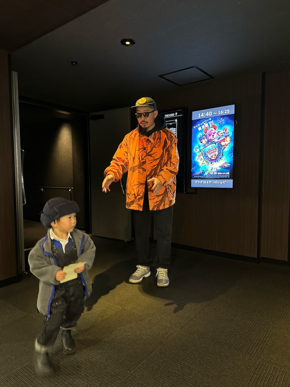 ブラック系のスウェットパンツ、グレー系のスニーカー、オレンジ系のその他アウターを着用したメンズの冬コーディネートの2枚目の写真