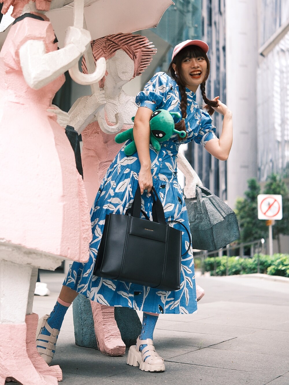 ブルー系のワンピース、ホワイト系のサンダル、ピンク系のキャップを着用したレディースの冬コーディネートの2枚目の写真