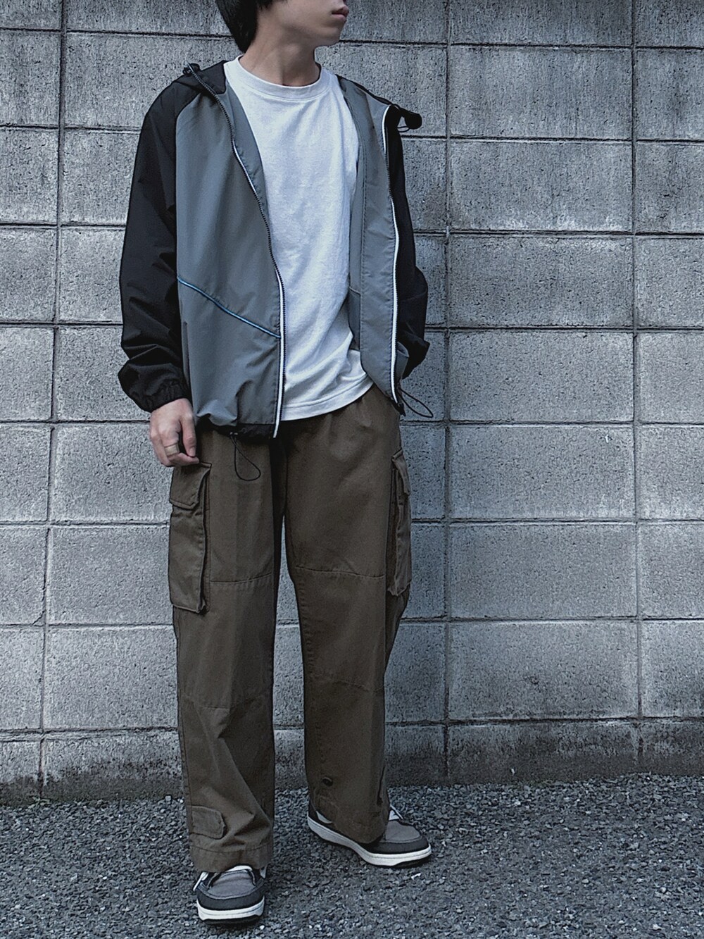 ホワイト系のTシャツ/カットソー、ブラック系のマウンテンパーカー、グリーン系のカーゴパンツを着用したメンズの春コーディネートの2枚目の写真