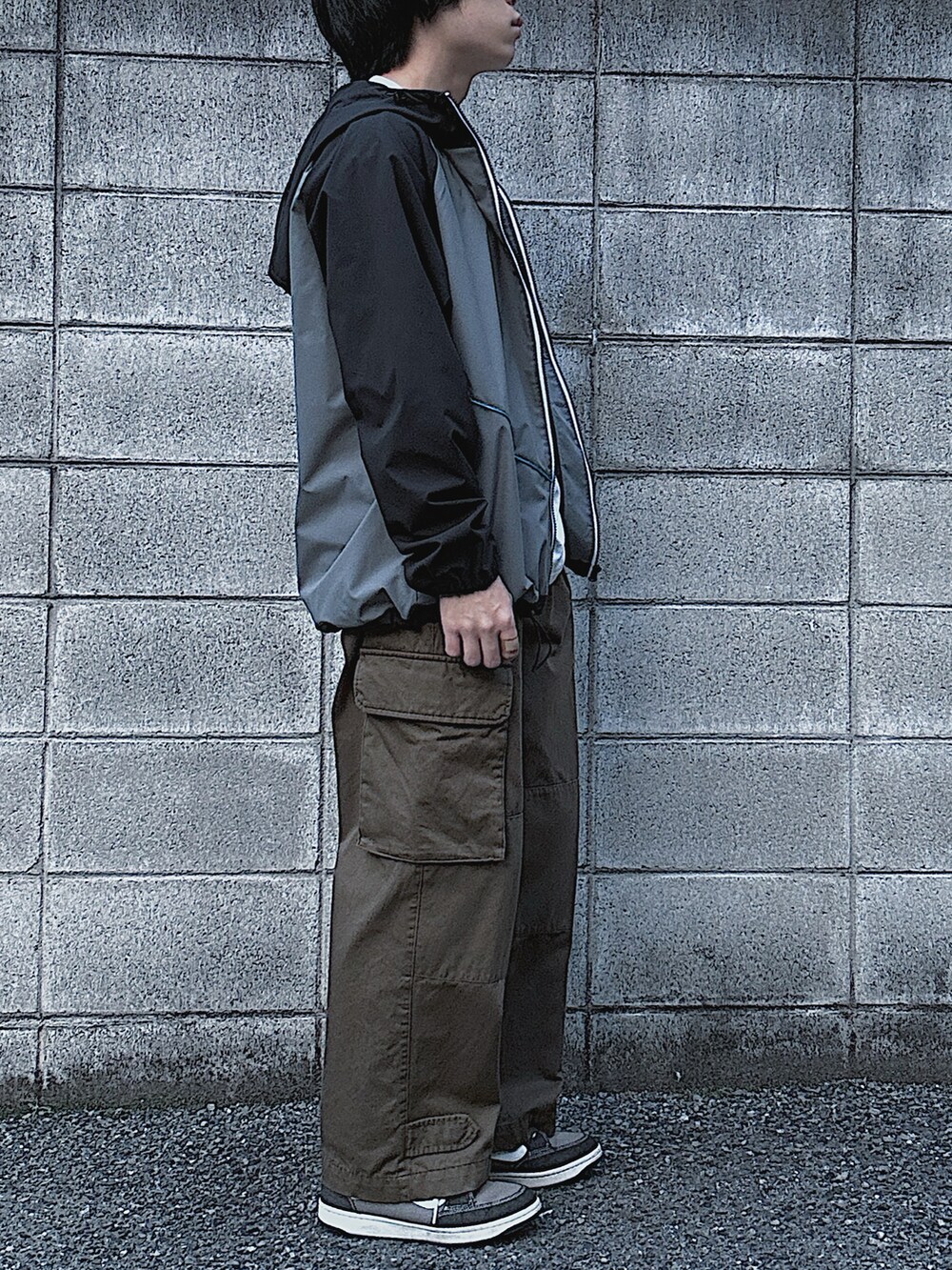 ホワイト系のTシャツ/カットソー、ブラック系のマウンテンパーカー、グリーン系のカーゴパンツを着用したメンズの春コーディネートの3枚目の写真